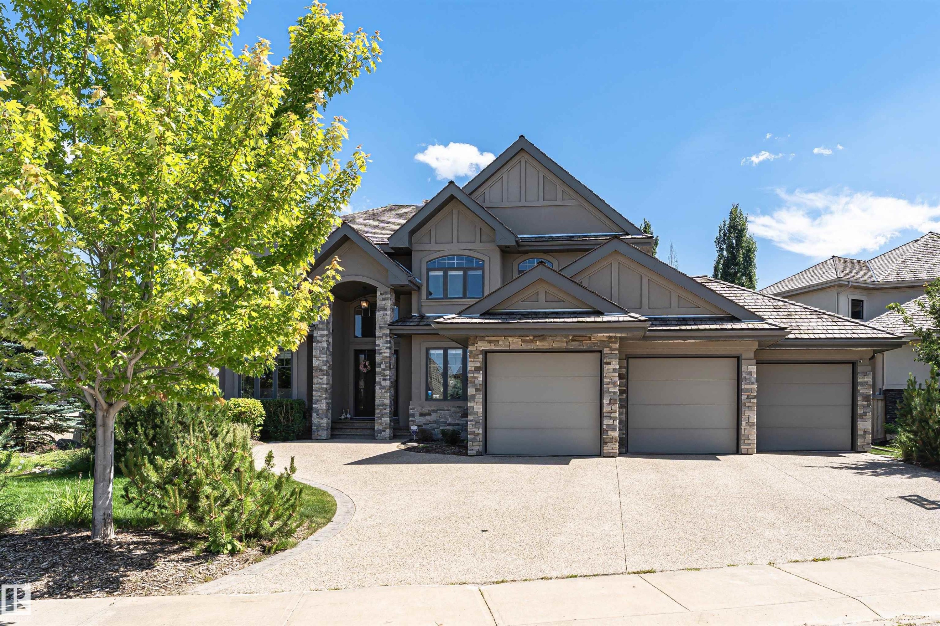Contemporary-style residence featuring a multi-gabled roofline and stone and stucco exterior - 3503 Watson Point(E), Edmonton, AB