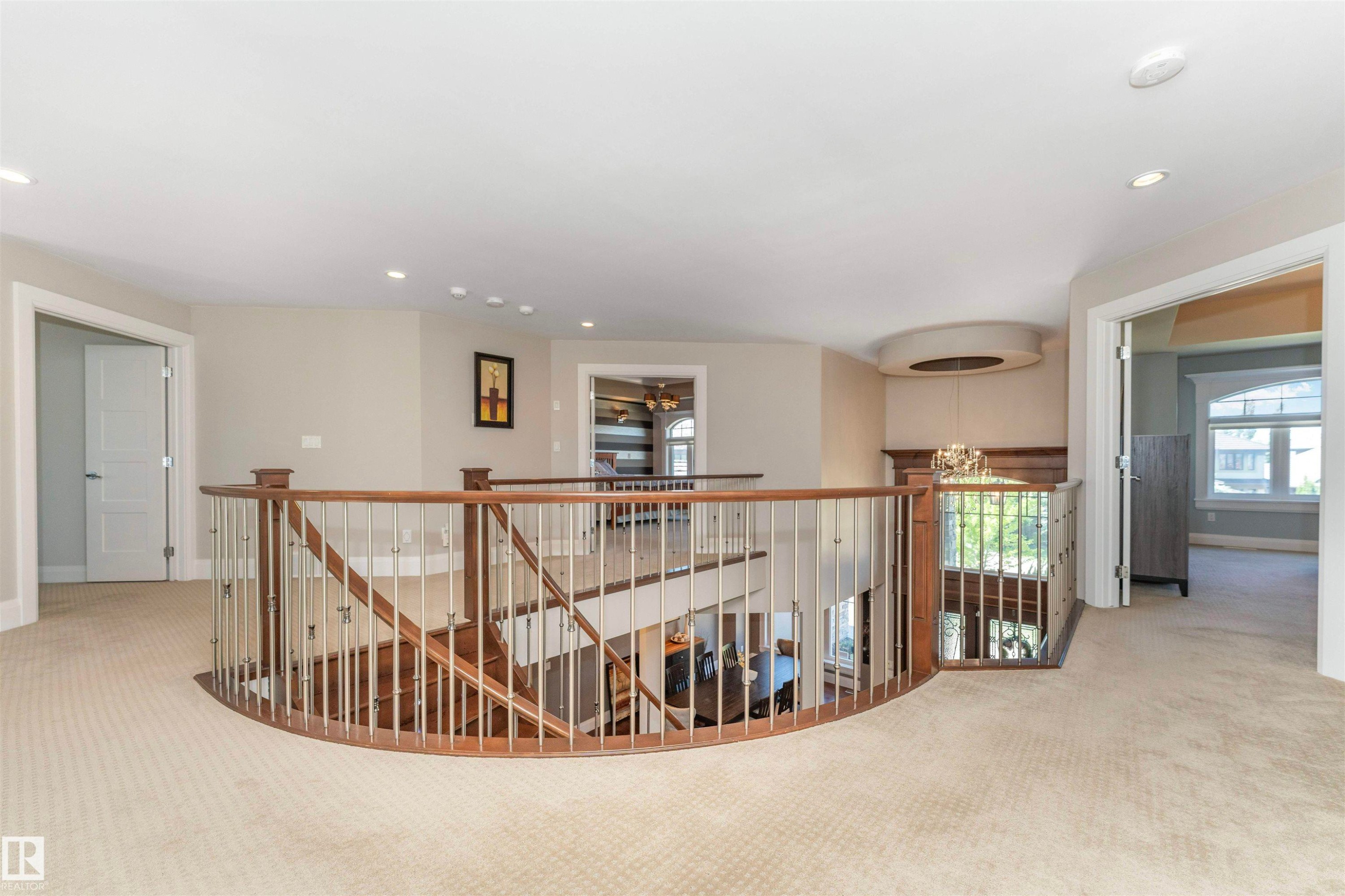 Curved staircase with wood-finish railing and metal balusters - 3503 Watson Point(E), Edmonton, AB