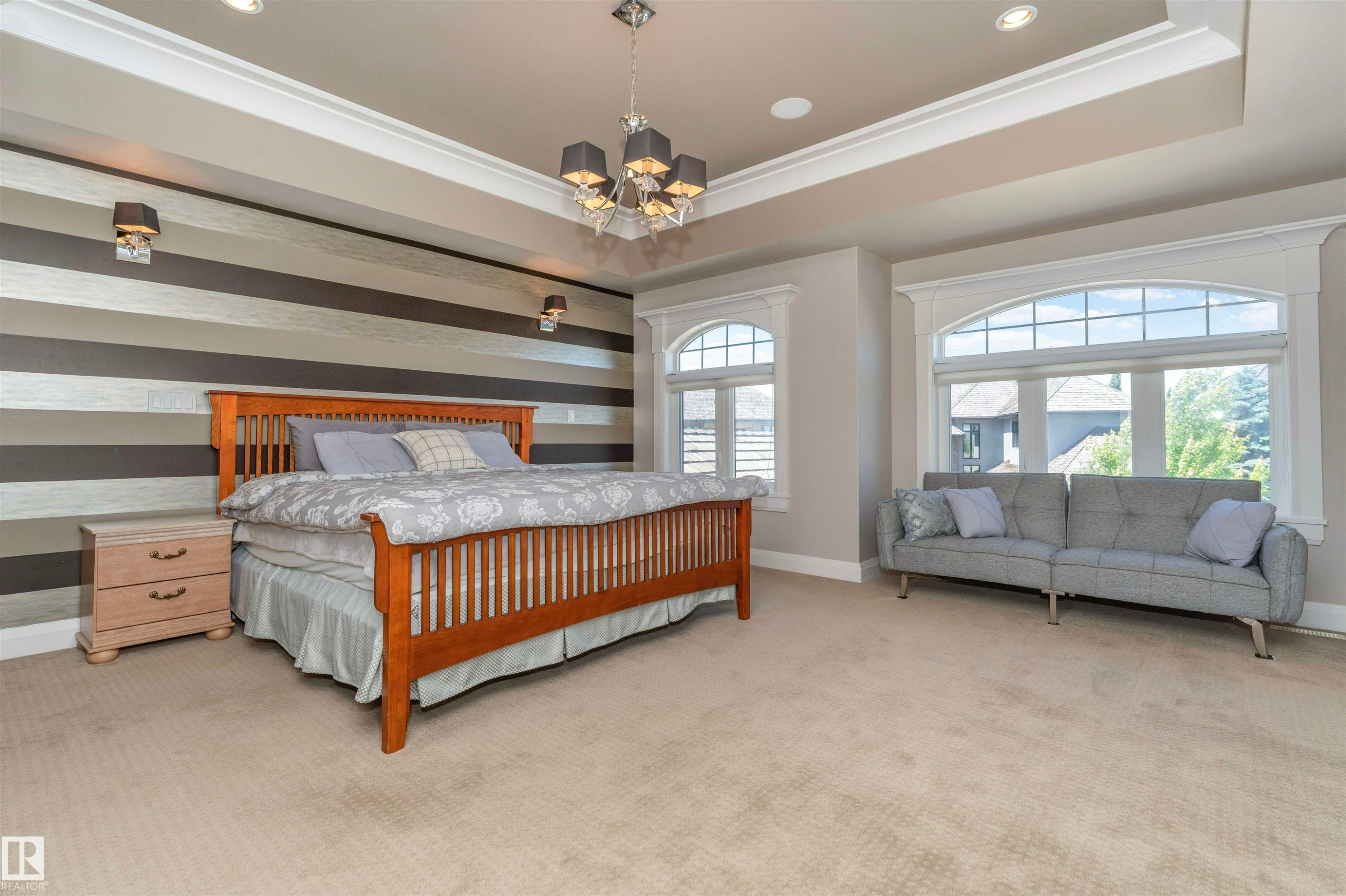 Spacious bedroom featuring a tray ceiling with crown molding, a decorative chandelier, and recessed lighting - 3503 Watson Point(E), Edmonton, AB