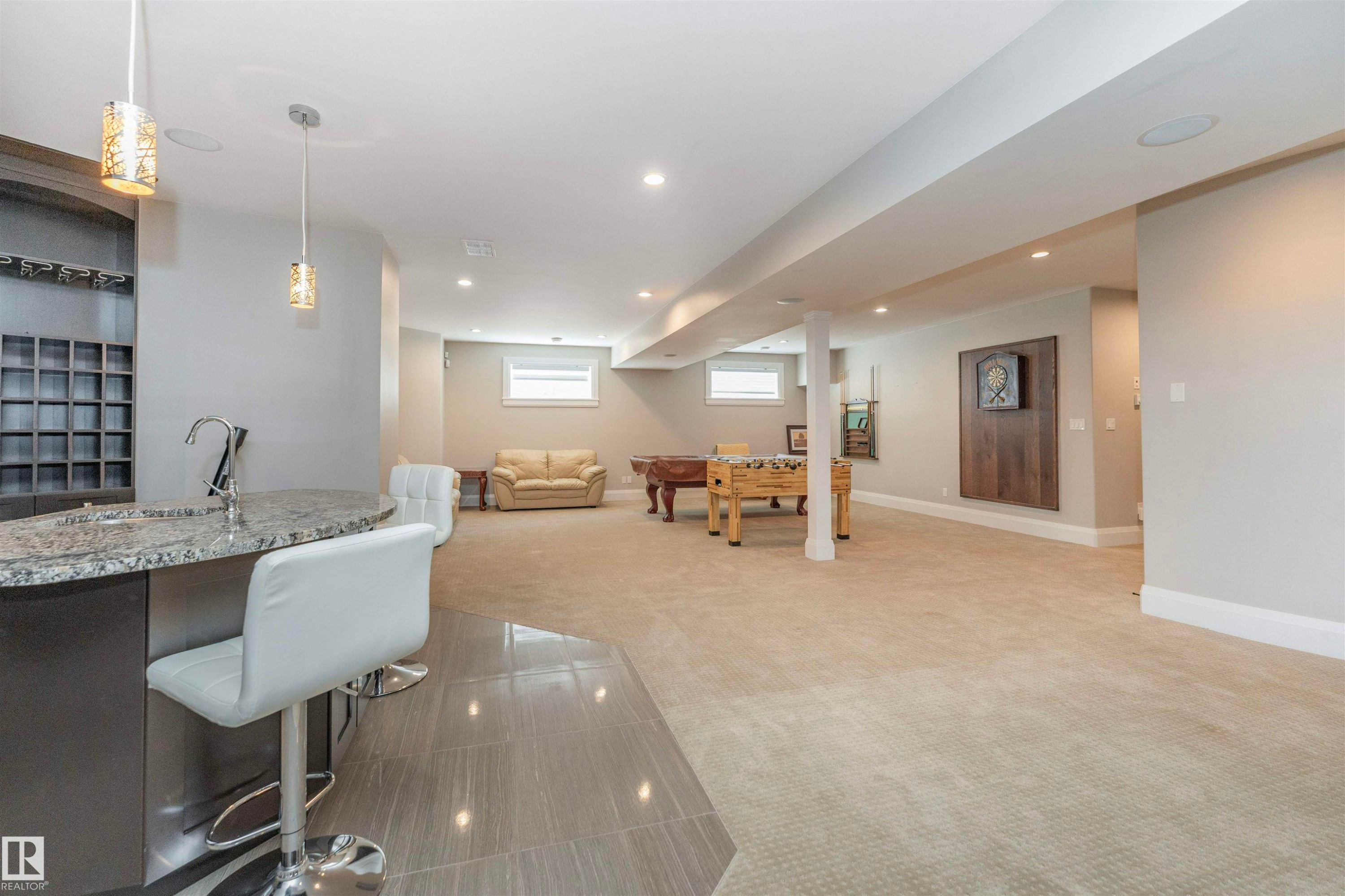 Spacious finished lower level featuring a built-in wet bar with pendant lighting, granite countertop, and integrated wine storage - 3503 Watson Point(E), Edmonton, AB