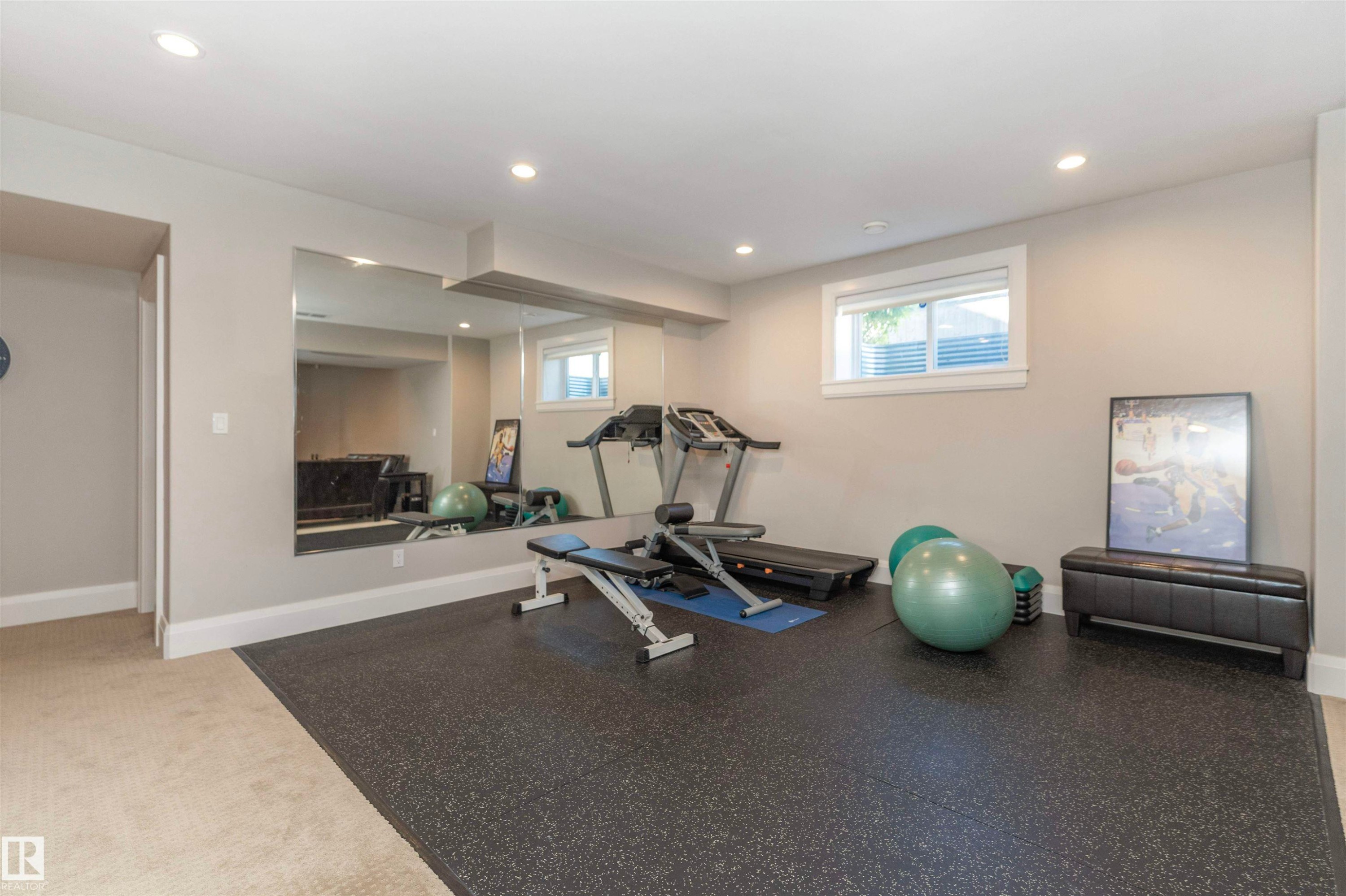 Spacious flex room with recessed lighting, full-wall mirror, rubberized flooring, and an egress window - 3503 Watson Point(E), Edmonton, AB