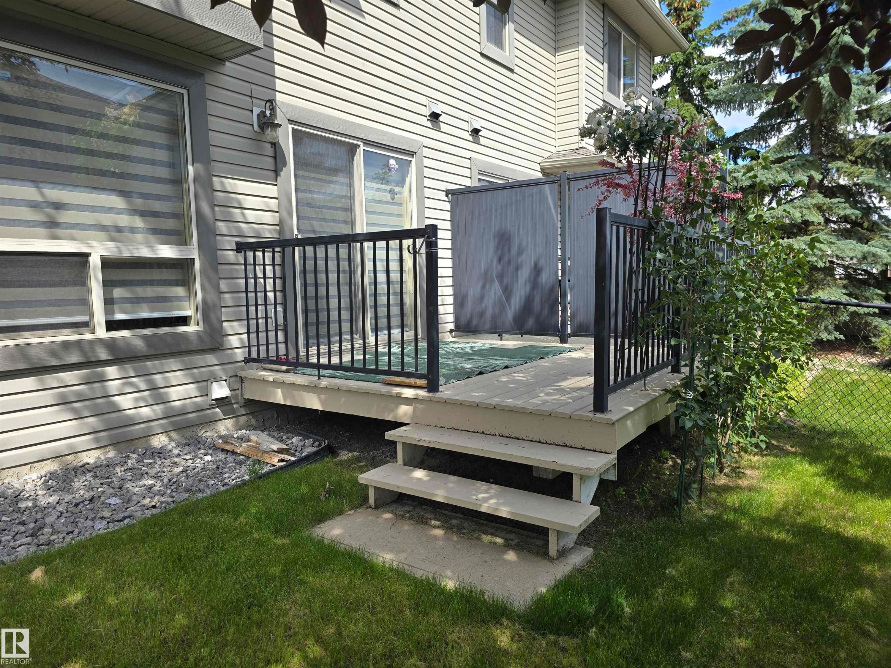 Outdoor deck featuring black metal railings and privacy screen - 60 1128 156 Street, Edmonton, AB