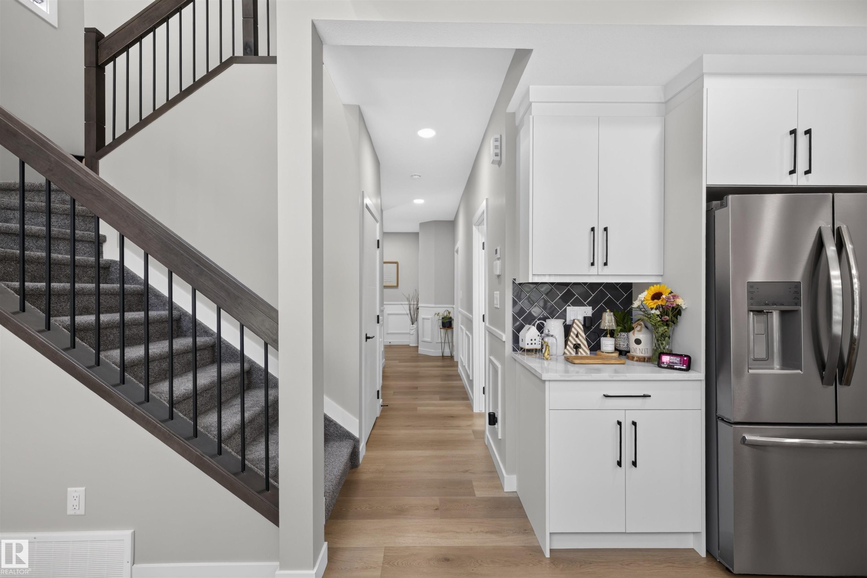 Staircase featuring dark wood handrails and black metal balusters - 1573 Esaiw Place Nw, Edmonton, AB