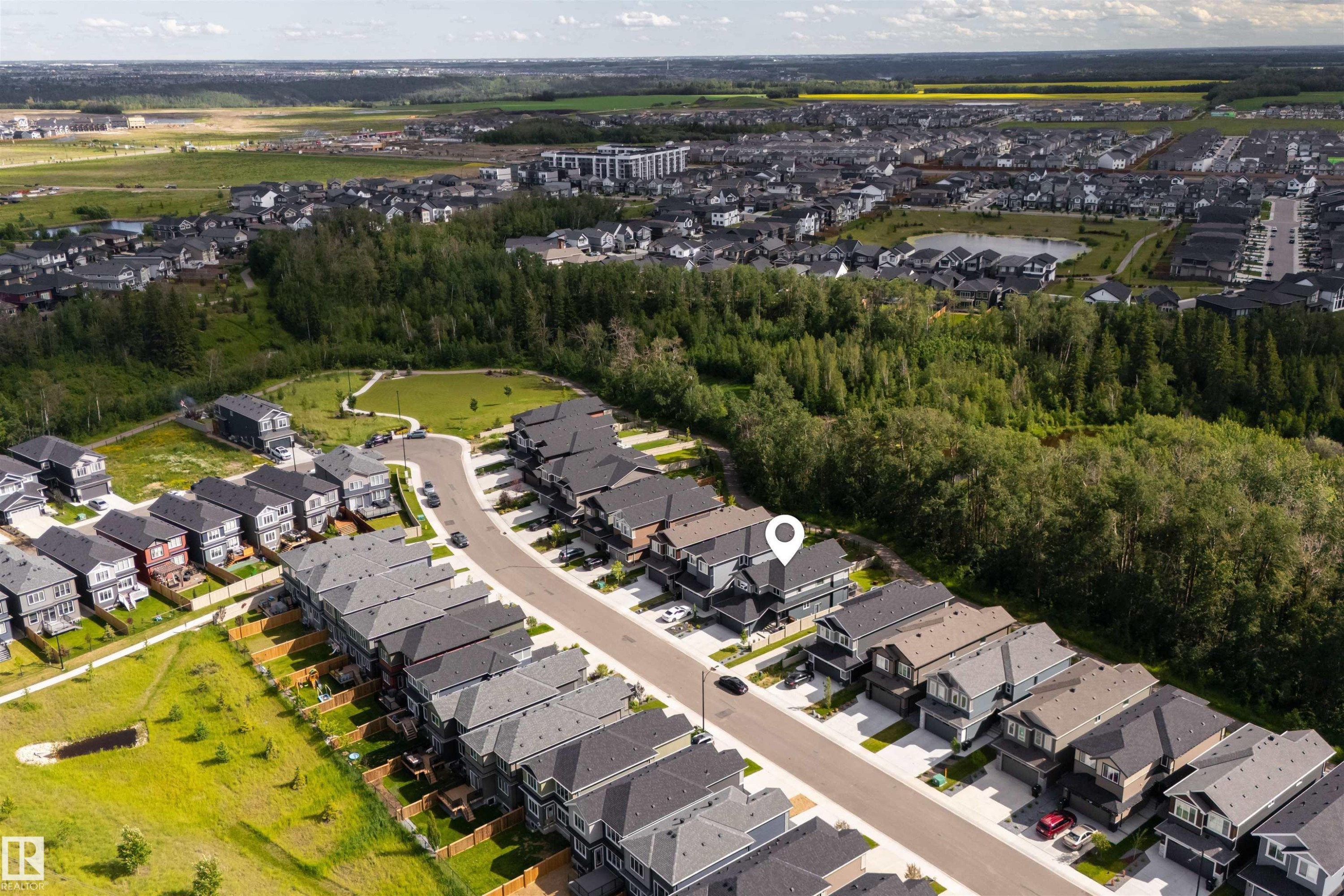 Aerial perspective showcasing a residential development with extensive green spaces and mature trees - 1573 Esaiw Place Nw, Edmonton, AB