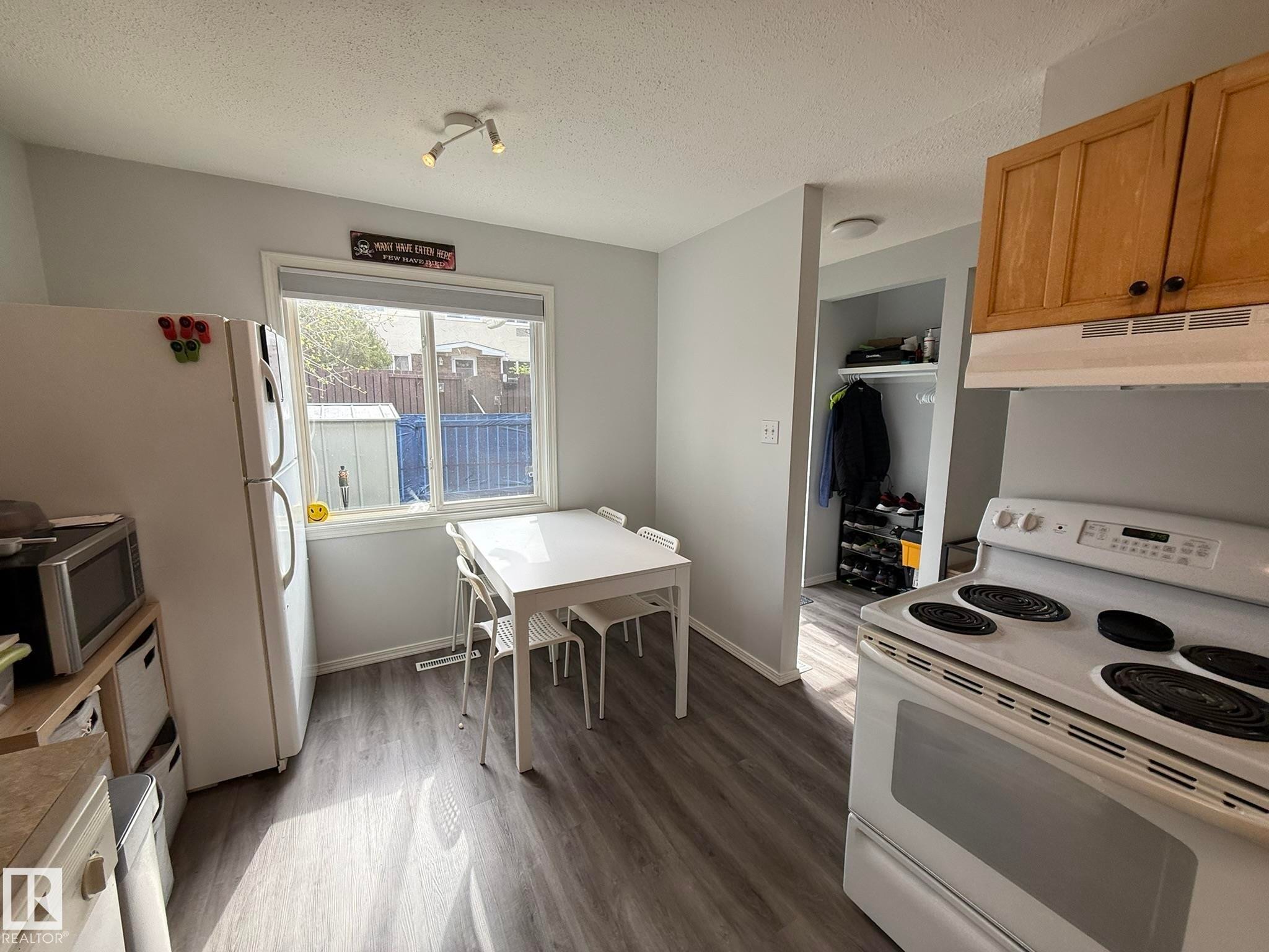Kitchen featuring wood-finish flooring, light grey walls, a window with blinds, and recessed lighting - 166 Roseland Village, Edmonton, AB - Indoor Photo Showing Kitchen