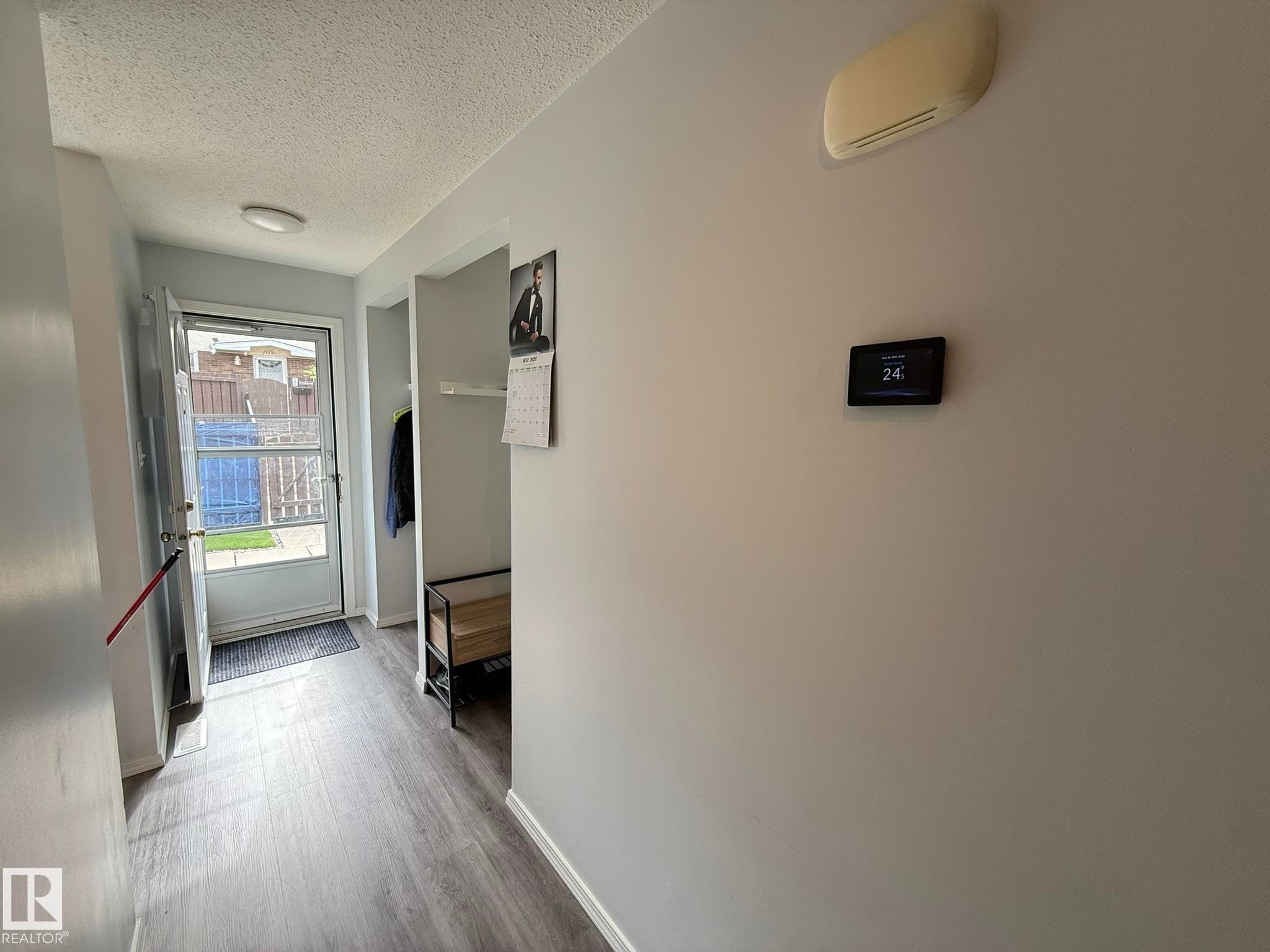 FRONT ENTRANCE HALLWAY TO THE LIVING ROOM, KITCHEN AND THE 2pc POWDER ROOM BEHIND THIS PHOTO! TAKE NOTE...THE PROGRAMABLE THERMOSTAT! - 166 Roseland Village, Edmonton, AB - Indoor Photo Showing Other Room