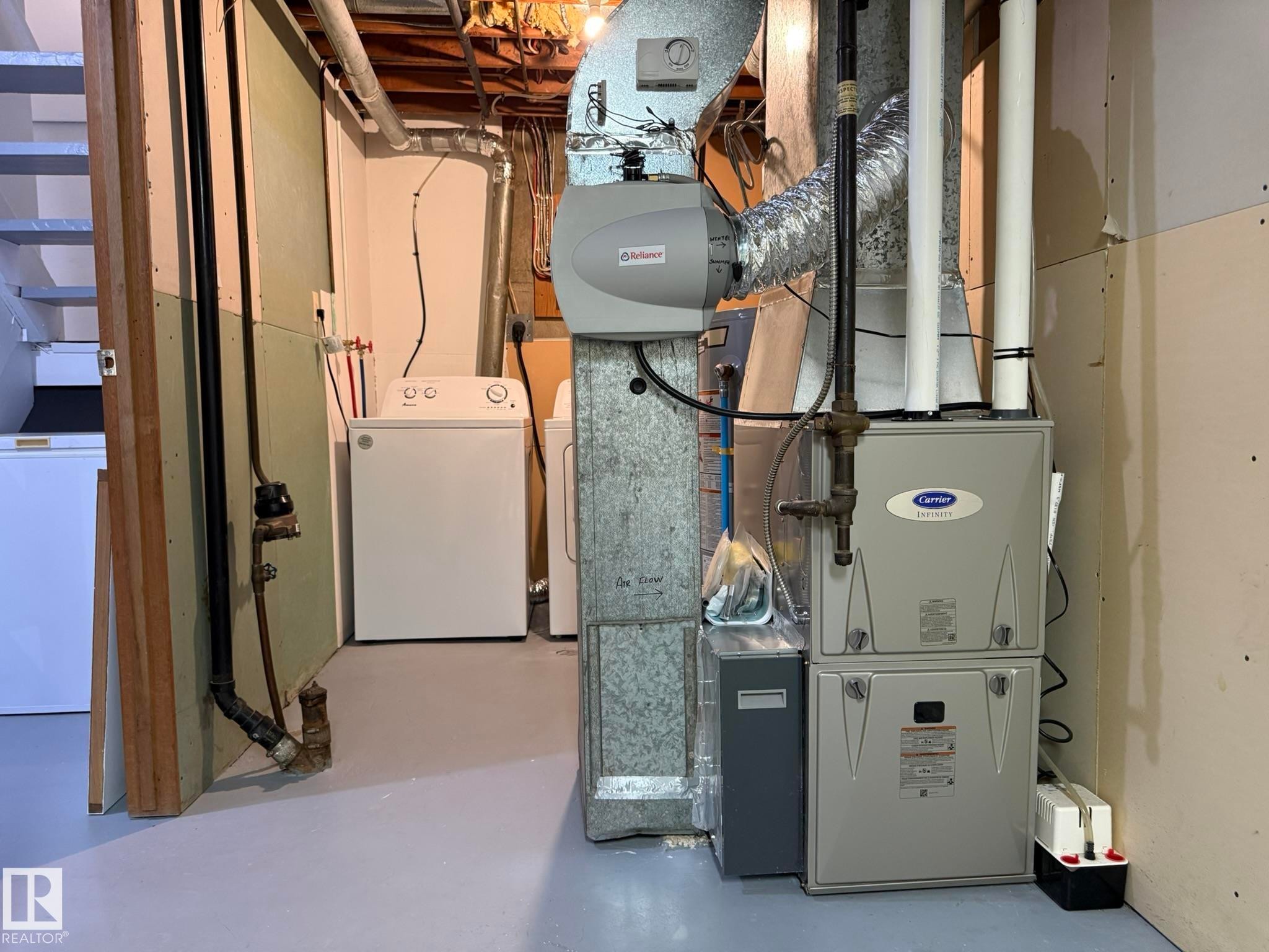 Utility area featuring a modern Carrier furnace, an Affinion humidifier, and exposed ductwork - 166 Roseland Village, Edmonton, AB - Indoor Photo Showing Basement