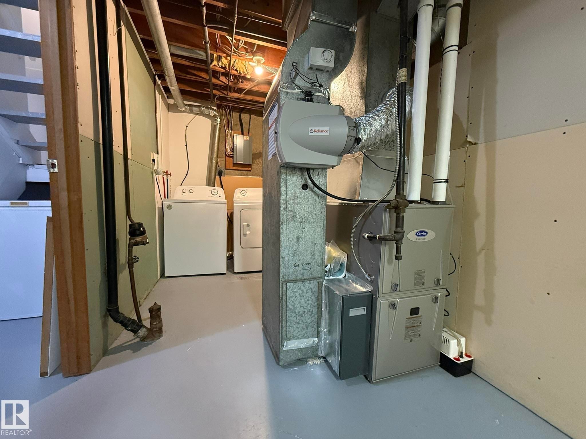 Utility area featuring a Carrier furnace, humidifier, and a dedicated laundry space with washer and dryer appliances - 166 Roseland Village, Edmonton, AB - Indoor Photo Showing Basement