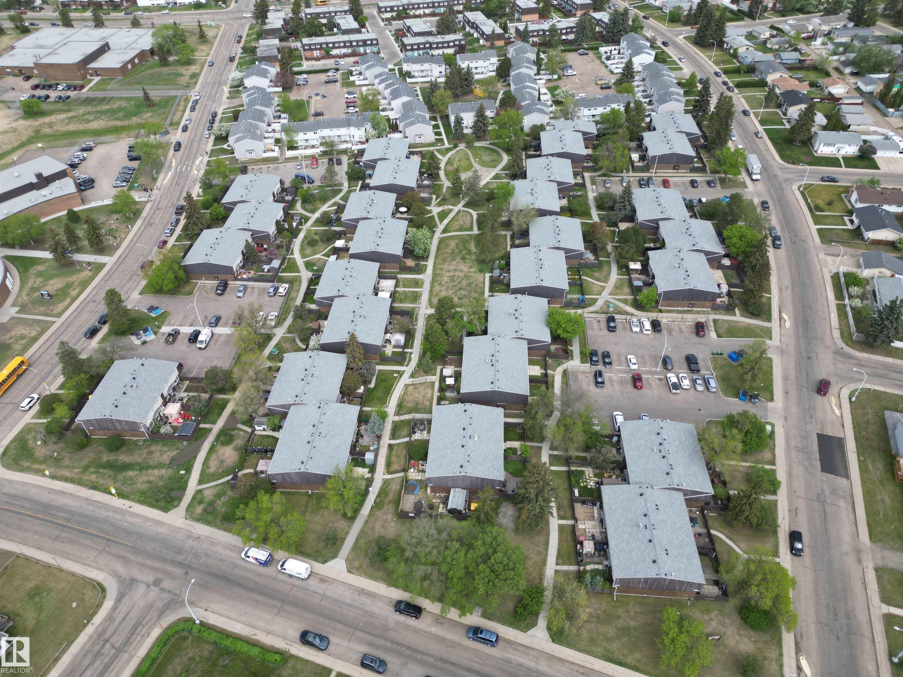 Aerial perspective showcasing a residential community layout with multiple buildings featuring gray shingle roofs - 166 Roseland Village, Edmonton, AB - Outdoor With View