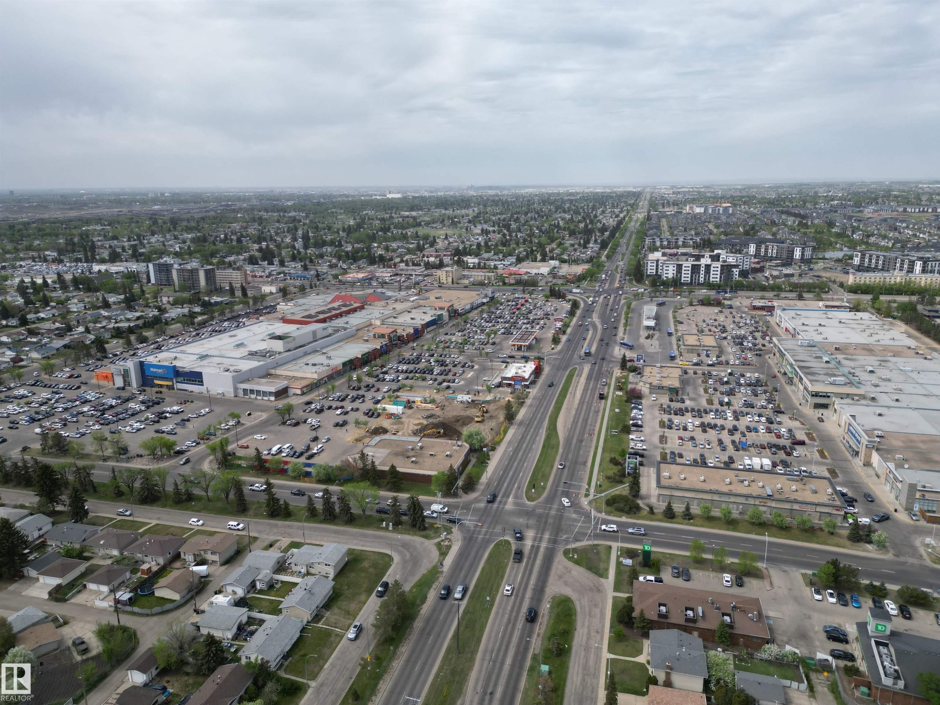 Aerial perspective showcasing a major commercial hub with extensive parking facilities, surrounded by residential areas and verdant tree-lined streets - 166 Roseland Village, Edmonton, AB - Outdoor With View