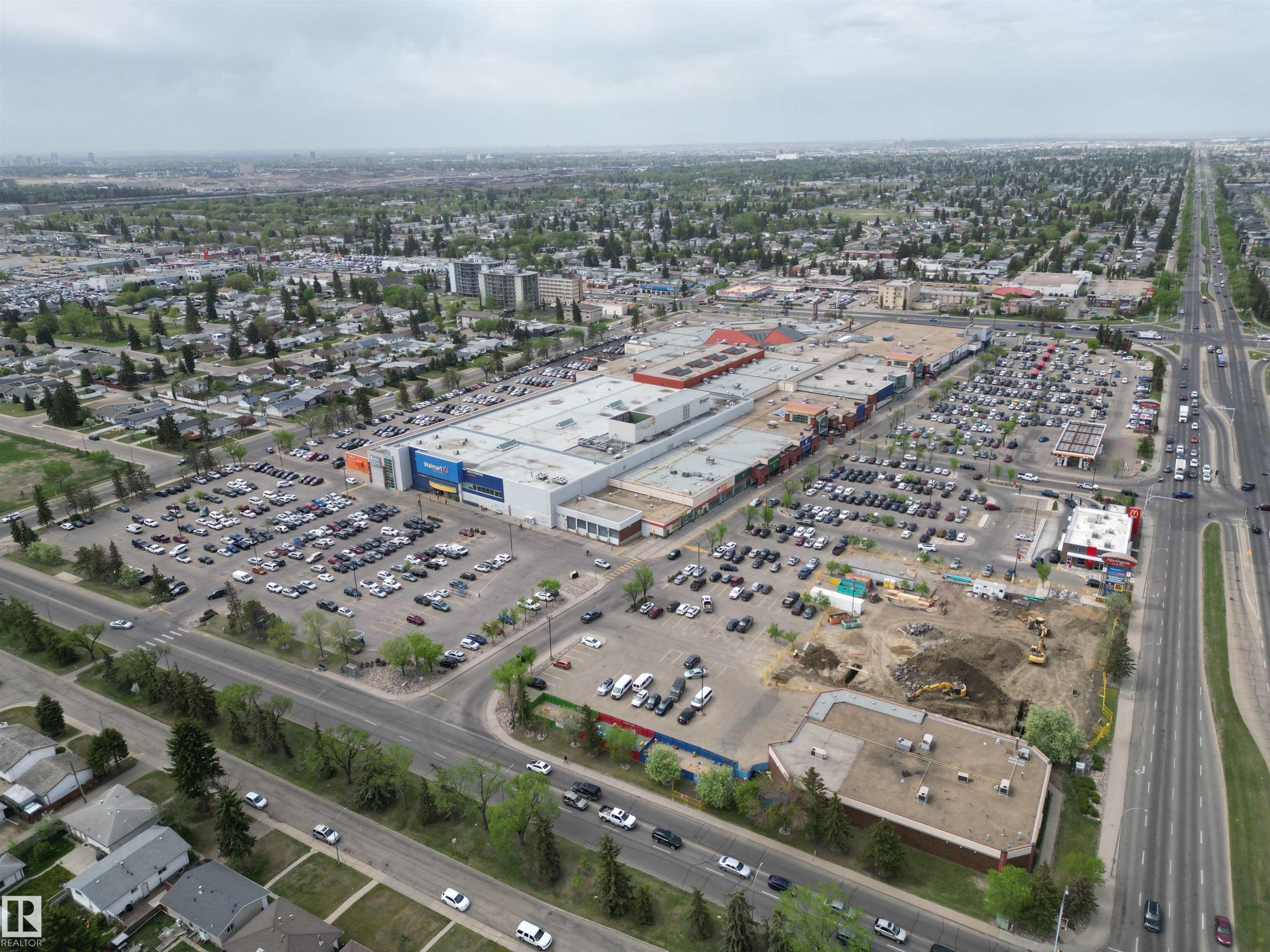 Expansive commercial property featuring a large retail complex, multiple surface parking lots, surrounding residential areas, and prominent arterial roadways - 166 Roseland Village, Edmonton, AB - Outdoor With View