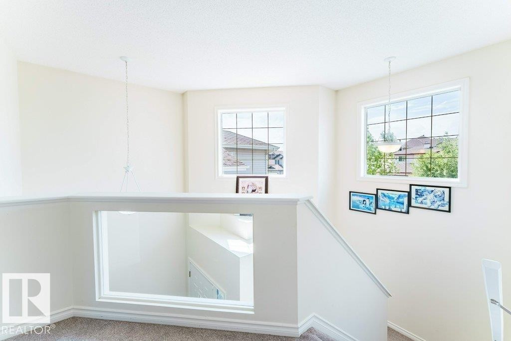 Upper-level landing featuring a carpeted floor, white painted walls, and white trim - 3525 22 Street, Edmonton, AB - Indoor Photo Showing Other Room