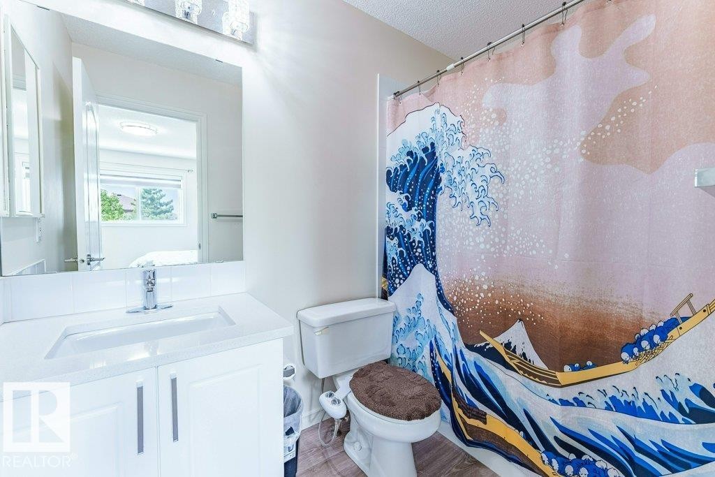 Bathroom featuring a single vanity with an integrated sink, white cabinetry, and chrome hardware - 3525 22 Street, Edmonton, AB - Indoor Photo Showing Bathroom
