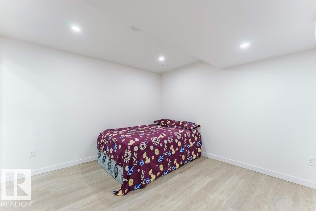 Recessed lighting illuminates this room featuring light wood-finish flooring and white baseboards - 3525 22 Street, Edmonton, AB - Indoor Photo Showing Bedroom