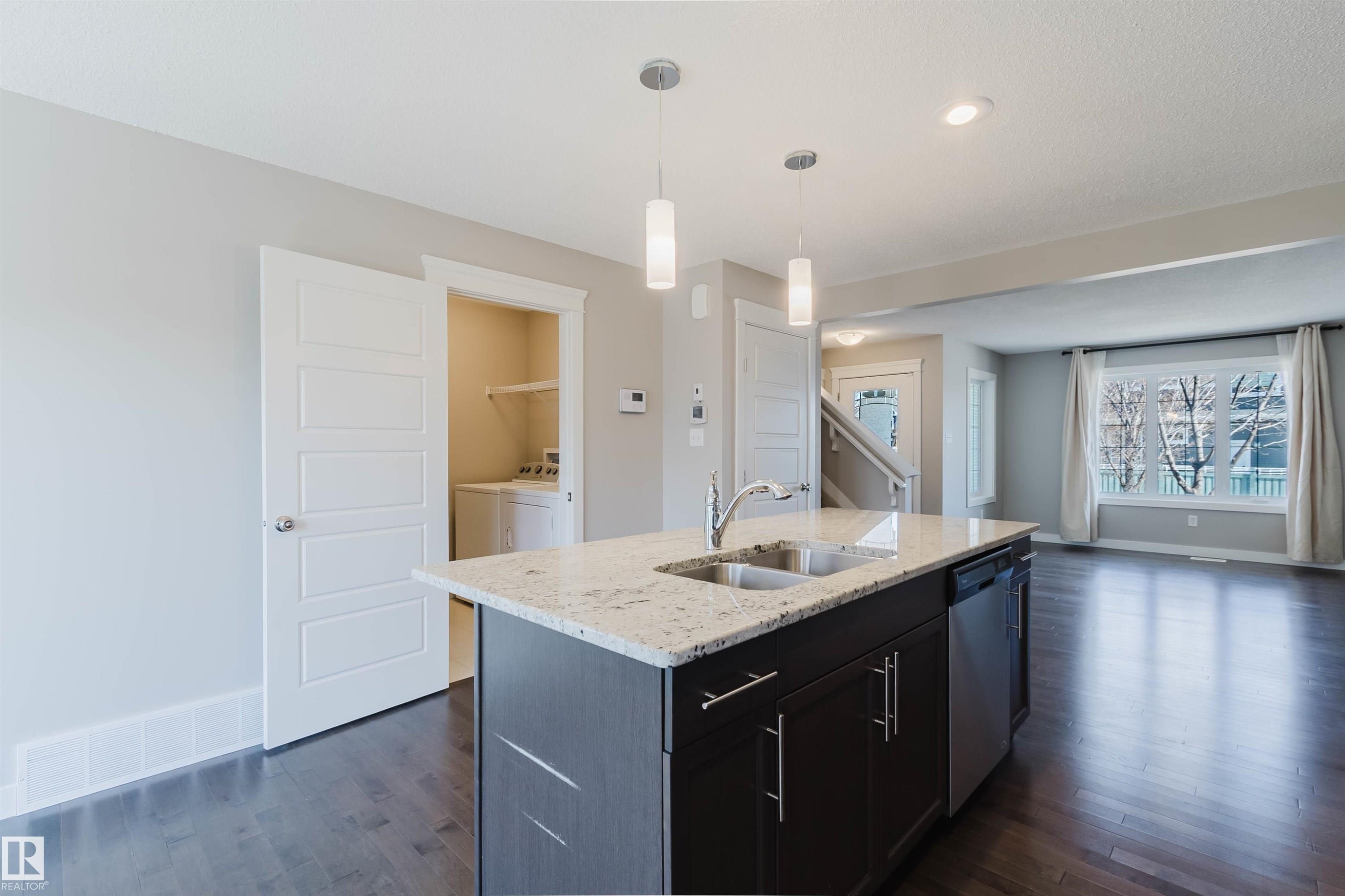 Kitchen island with light granite countertop and undermount double sink - 2472 Glenridding Boulevard, Edmonton, AB