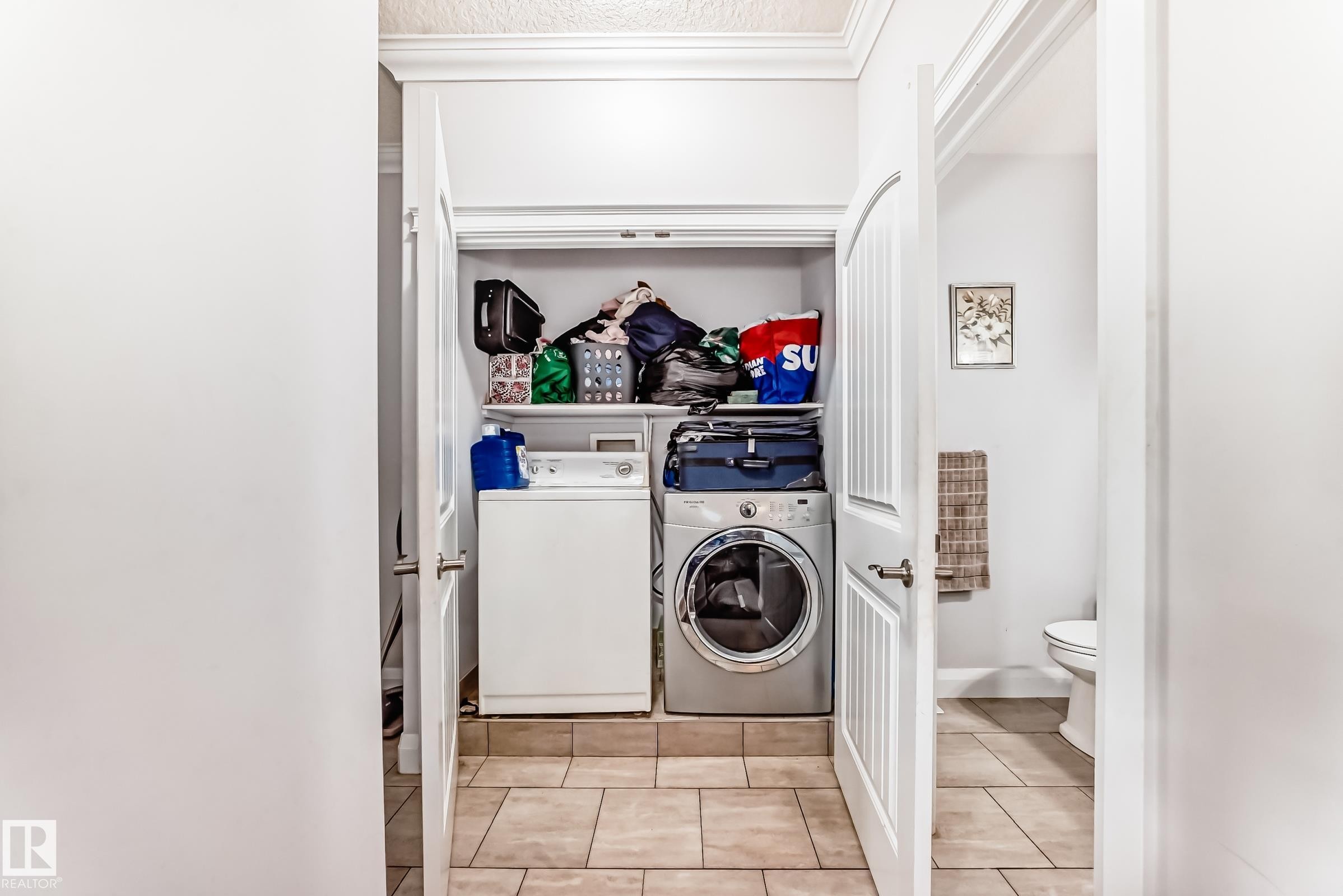 Dedicated laundry closet featuring a built-in shelf and tile flooring - #2 12042 101 St Nw, Edmonton, AB - Indoor Photo Showing Laundry Room