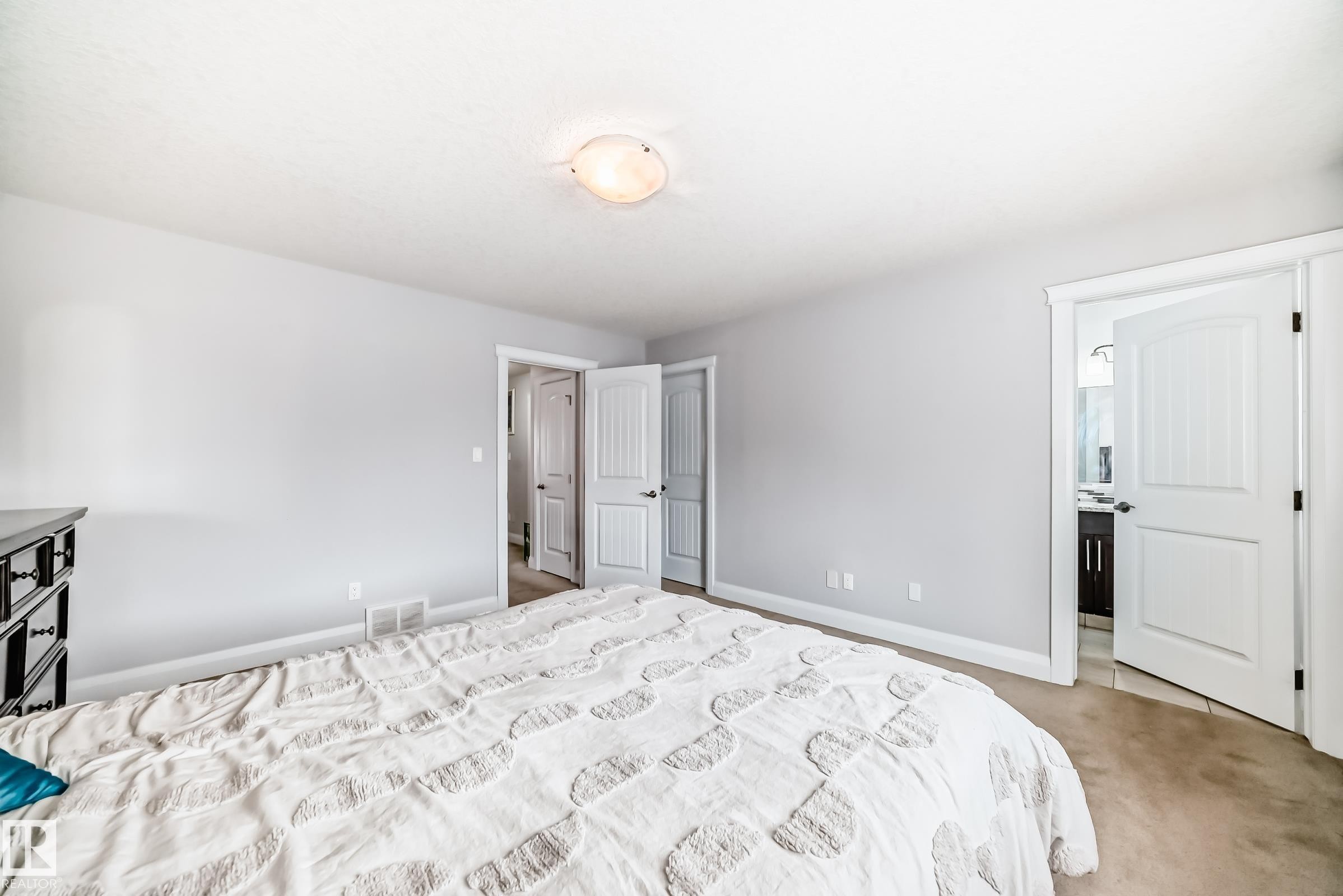 Spacious bedroom featuring light neutral walls and carpeted flooring - #2 12042 101 St Nw, Edmonton, AB - Indoor Photo Showing Bedroom