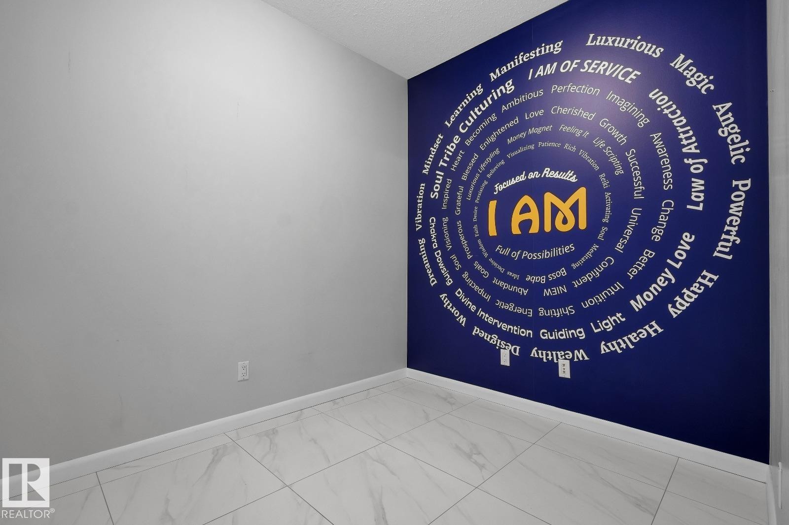 Interior space featuring a decorative accent wall with a circular graphic design - 105 160 Magrath Road, Edmonton, AB