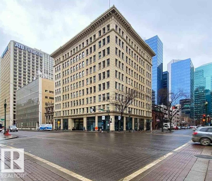 Historic 8-story commercial building featuring classic architectural detailing, ground-level retail spaces, and multiple upper-floor window arrangements - 210 10134 100 Street, Edmonton, AB