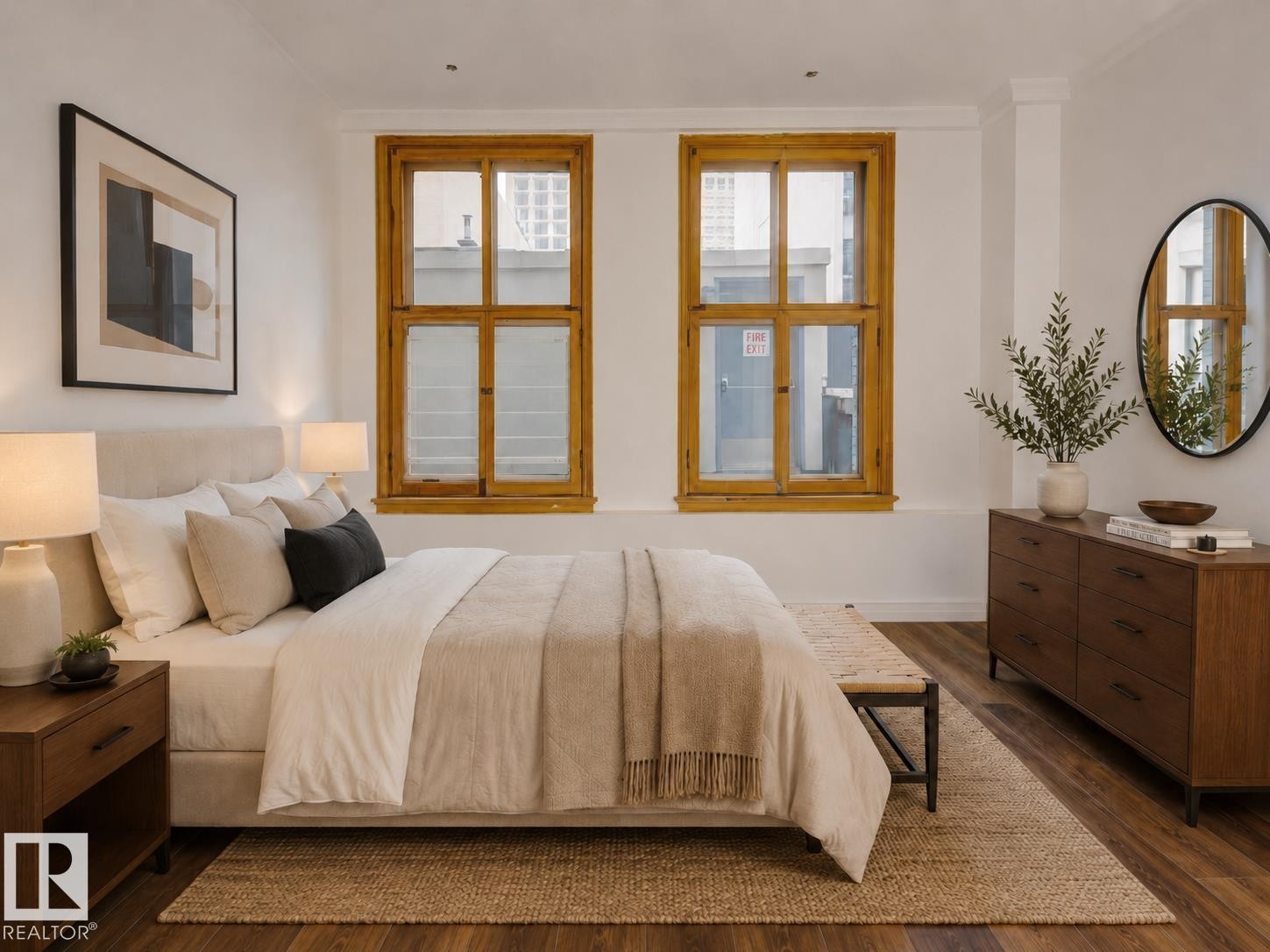 Warm wood-finish flooring complements the bright white walls and natural light from the two large windows - 210 10134 100 Street, Edmonton, AB