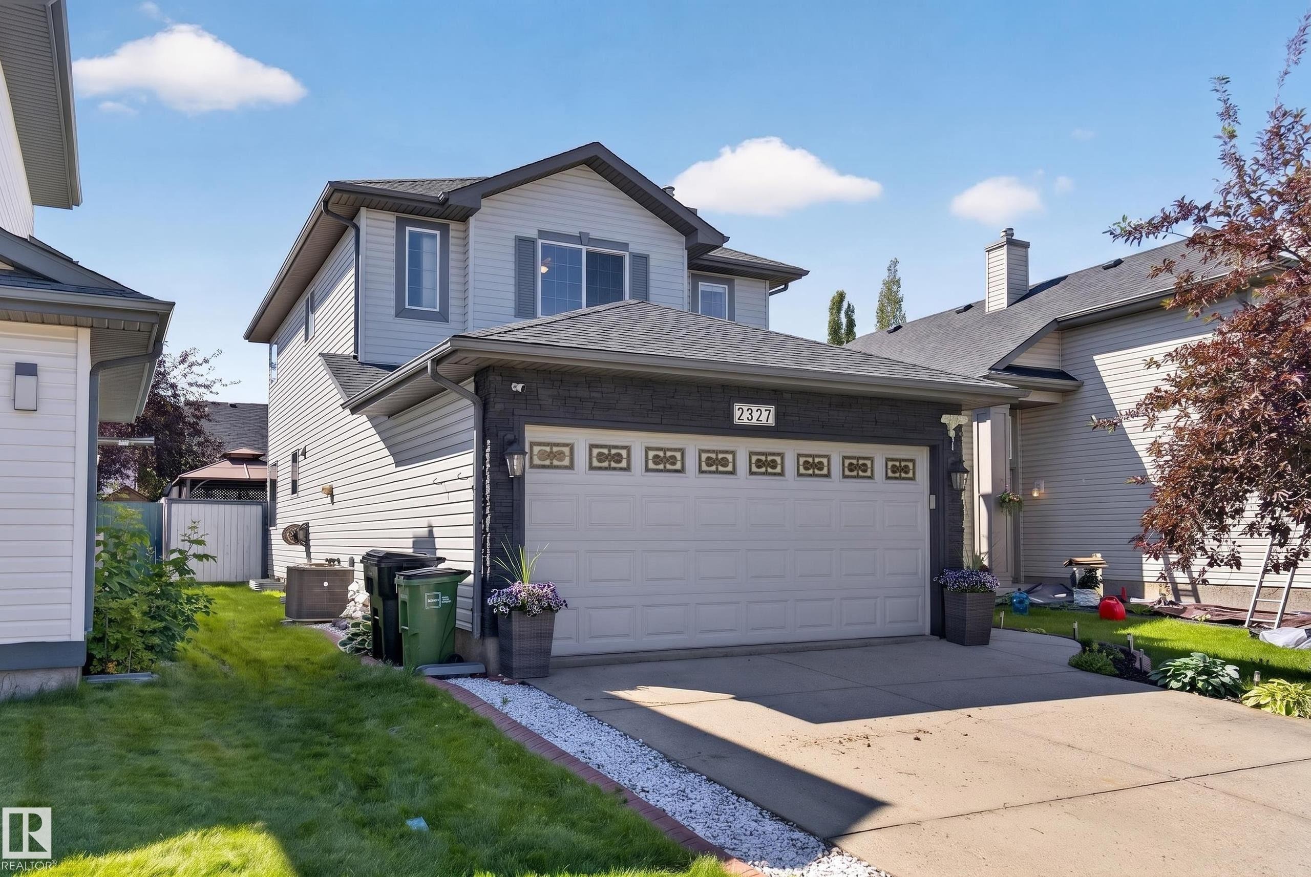 Two-story residence featuring light gray siding with dark trim accents and a contrasting roof - 2327 37B Avenue, Edmonton, AB