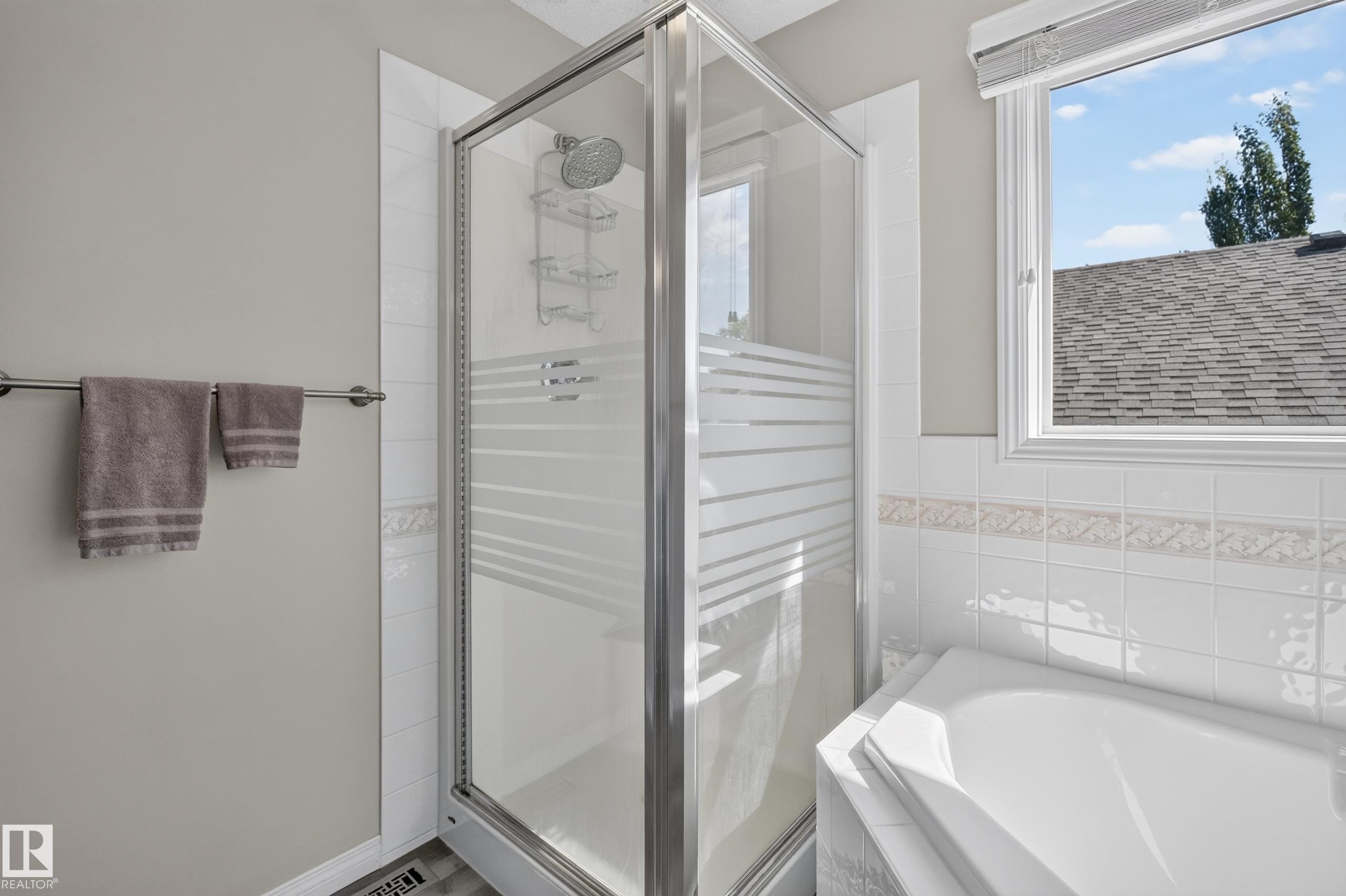 Glass-enclosed shower featuring a chrome showerhead and built-in shelving - 2327 37B Avenue, Edmonton, AB