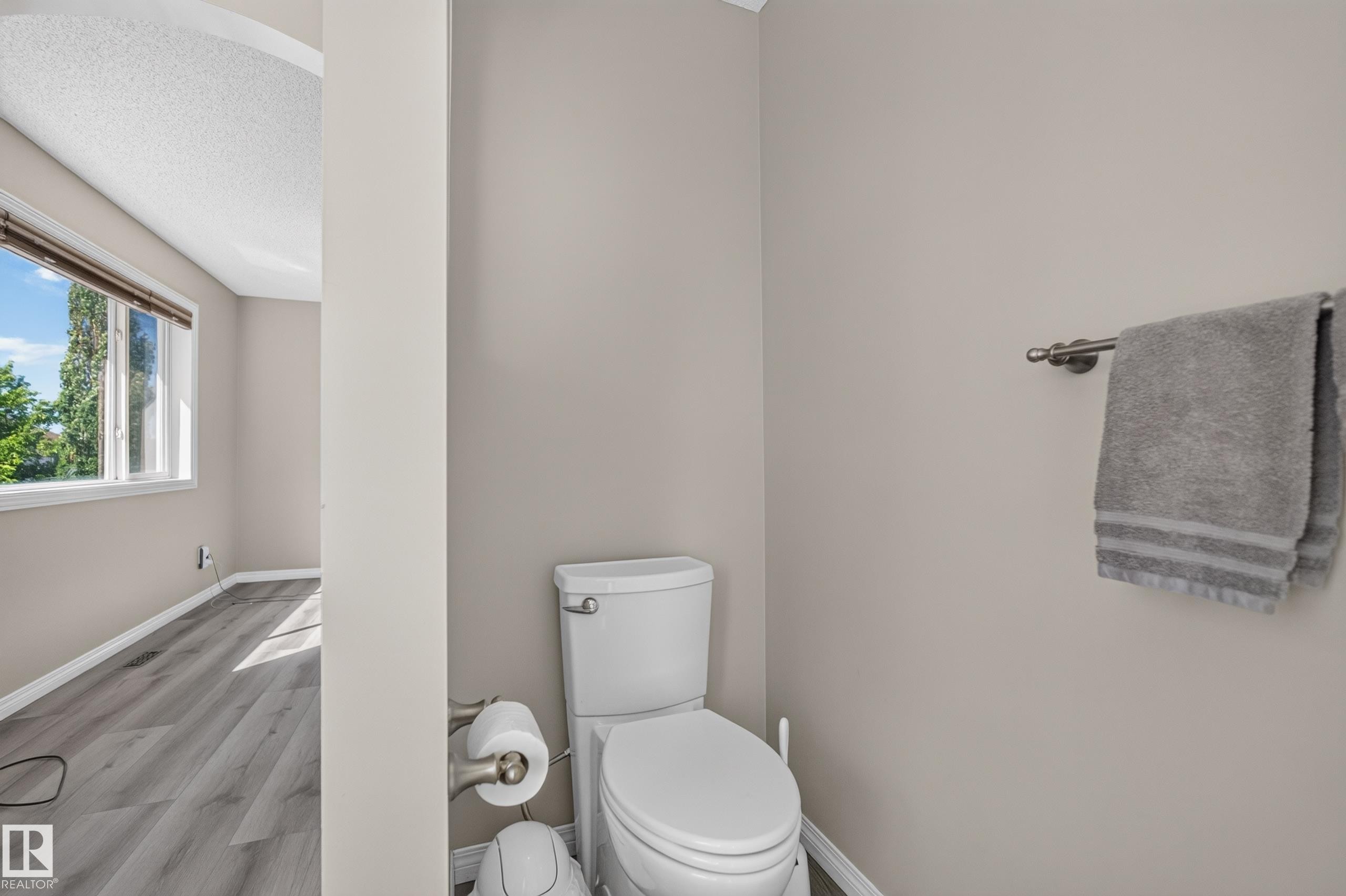 Bathroom featuring a white commode with a brushed nickel toilet paper holder - 2327 37B Avenue, Edmonton, AB
