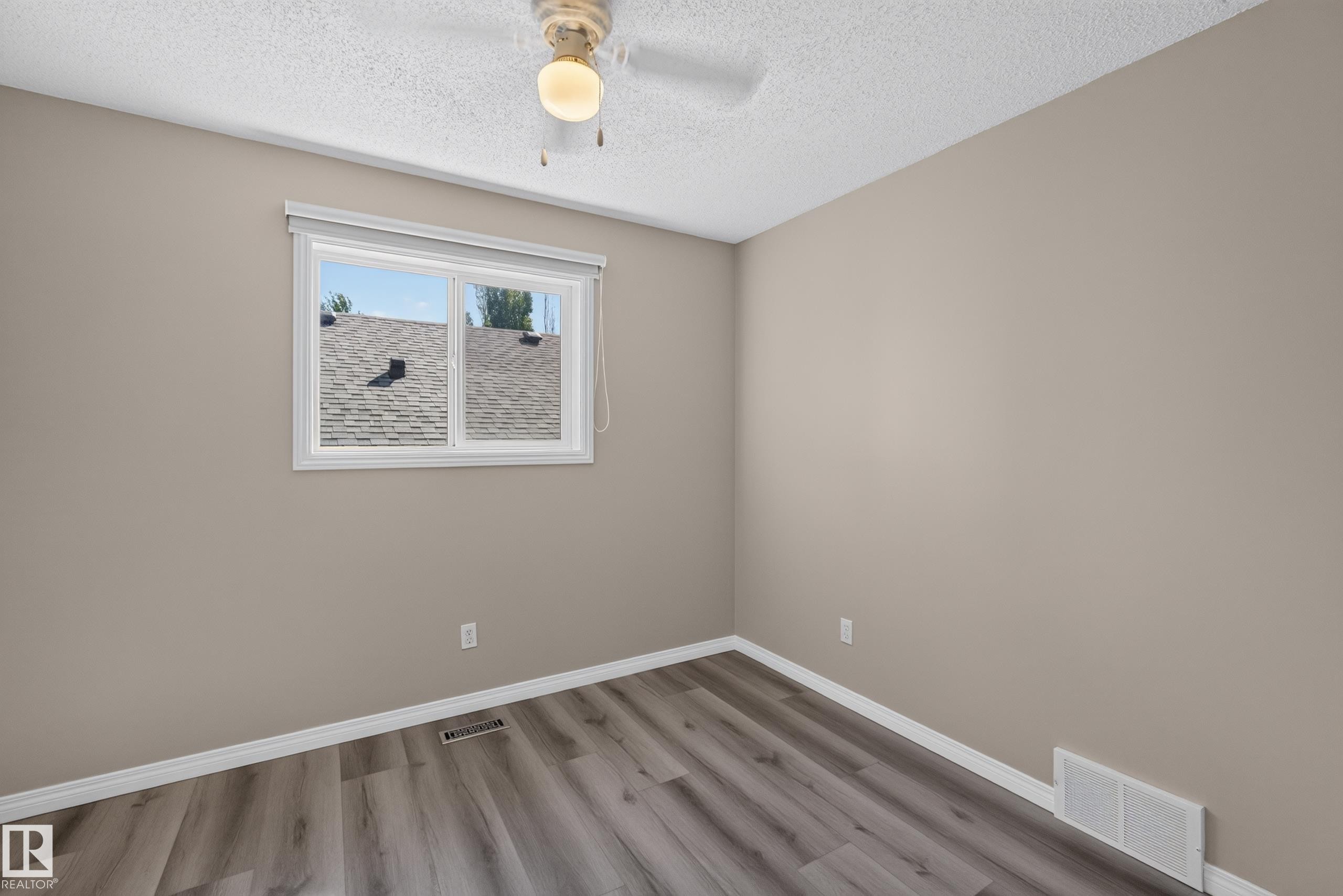 Neutral tone walls with white trim and wood-finish flooring - 2327 37B Avenue, Edmonton, AB