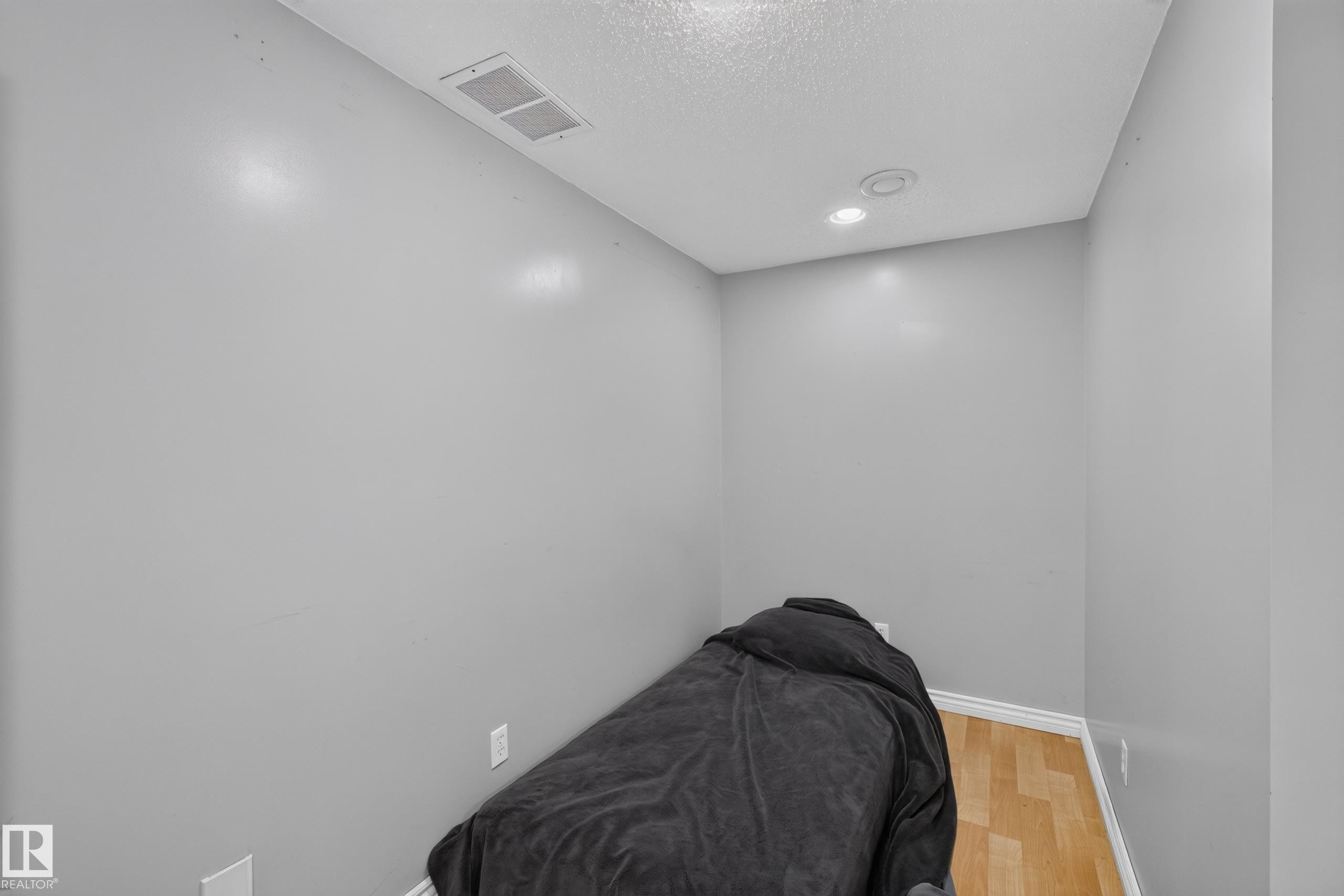 Room featuring light gray walls, wood-finish flooring, white baseboards, and recessed lighting - 2327 37B Avenue, Edmonton, AB