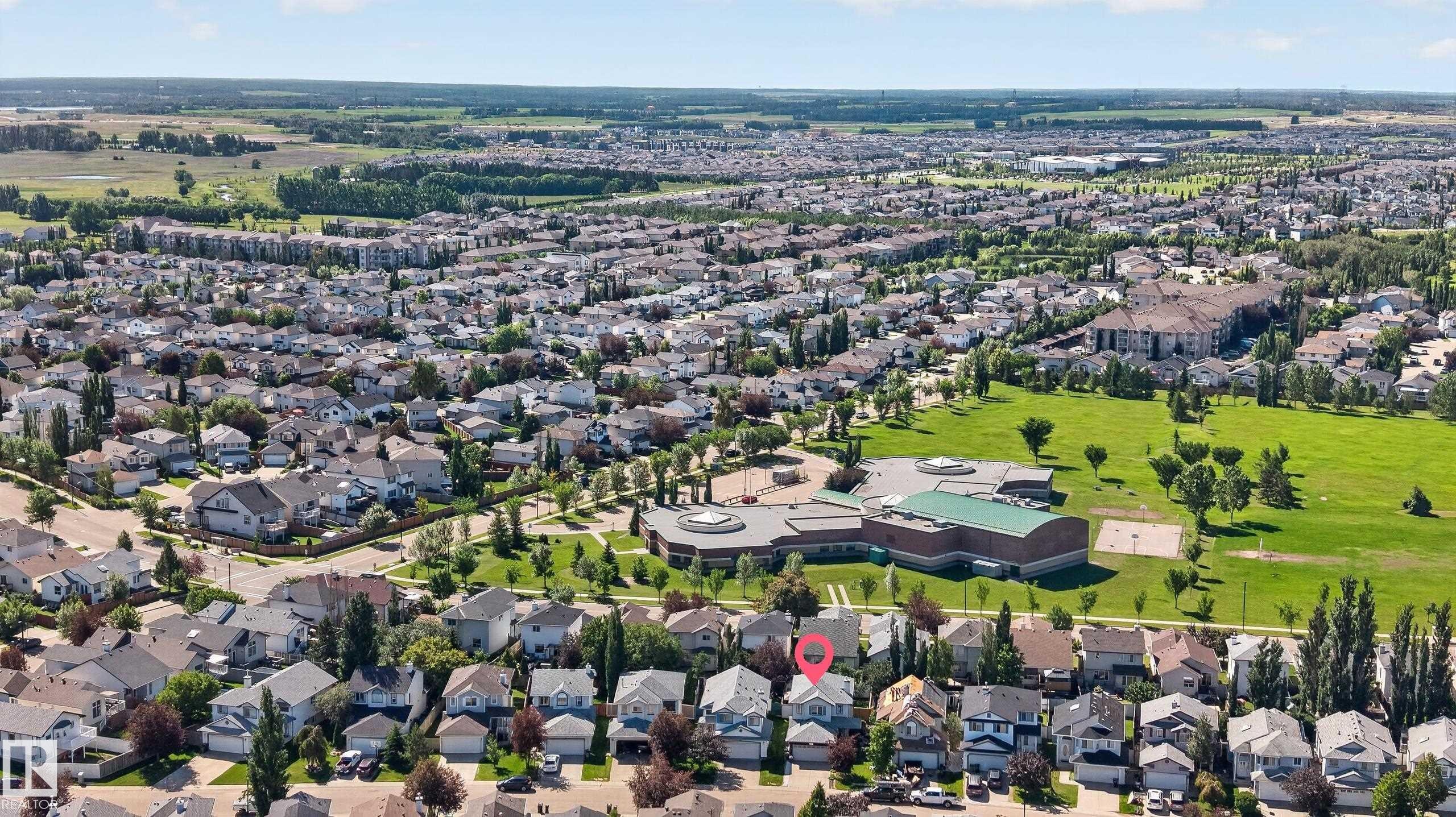 Aerial perspective showcasing a residential neighborhood with surrounding green spaces and agricultural areas - 2327 37B Avenue, Edmonton, AB