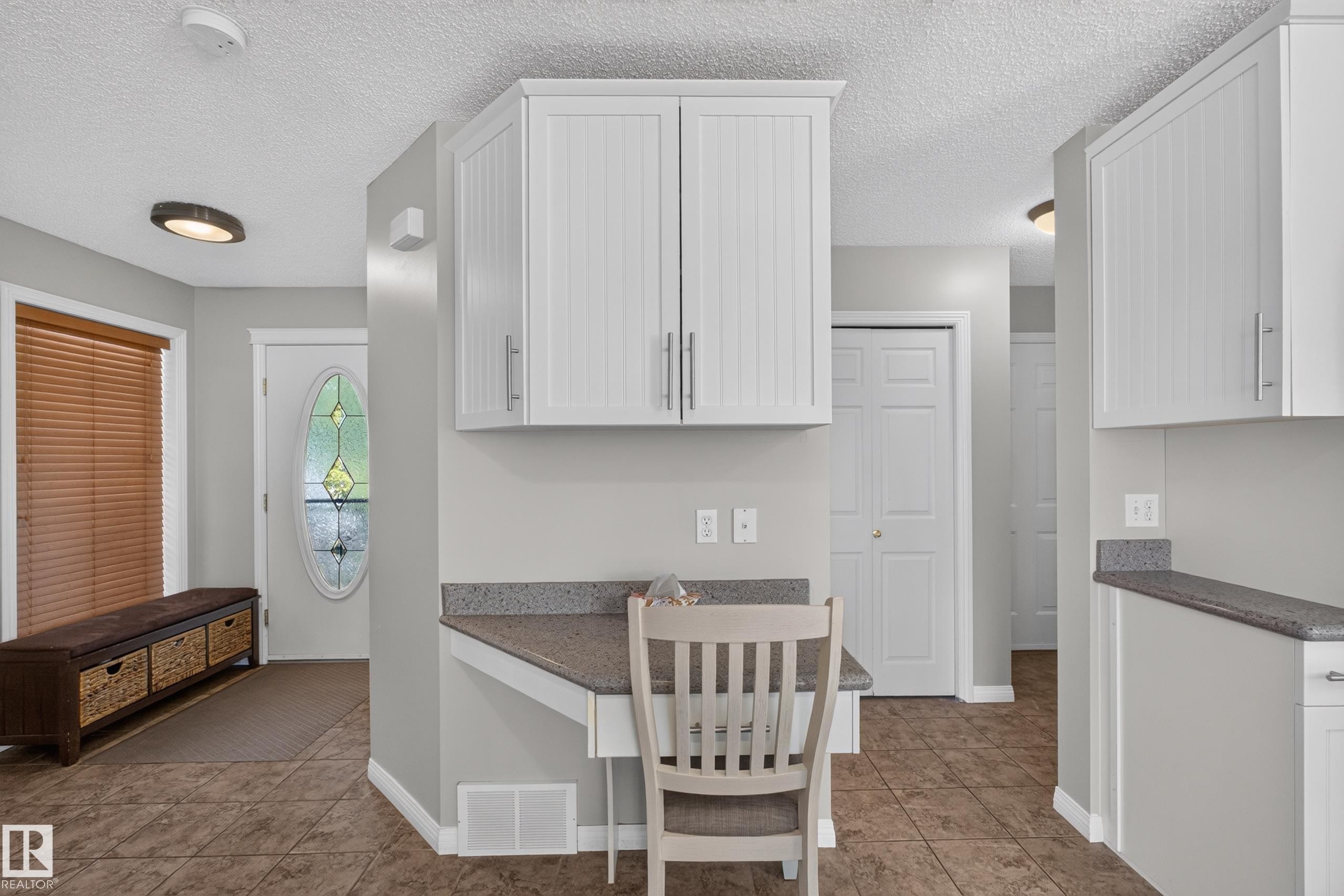 Built-in desk area with upper cabinetry and a stone-finish countertop - 2327 37B Avenue, Edmonton, AB