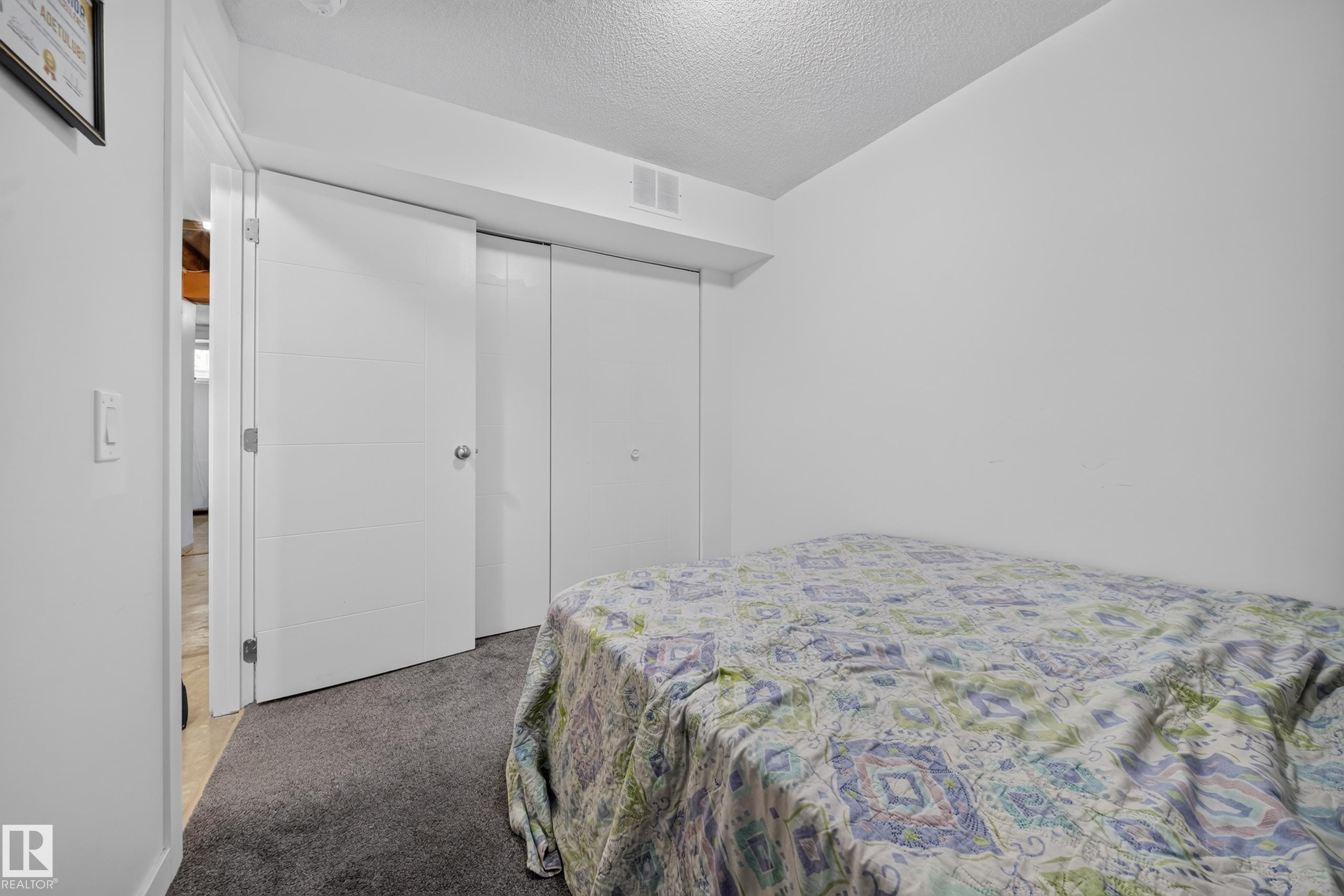 White walls and dark gray carpet flooring create a neutral palette - 59 2503 24 Street, Edmonton, AB