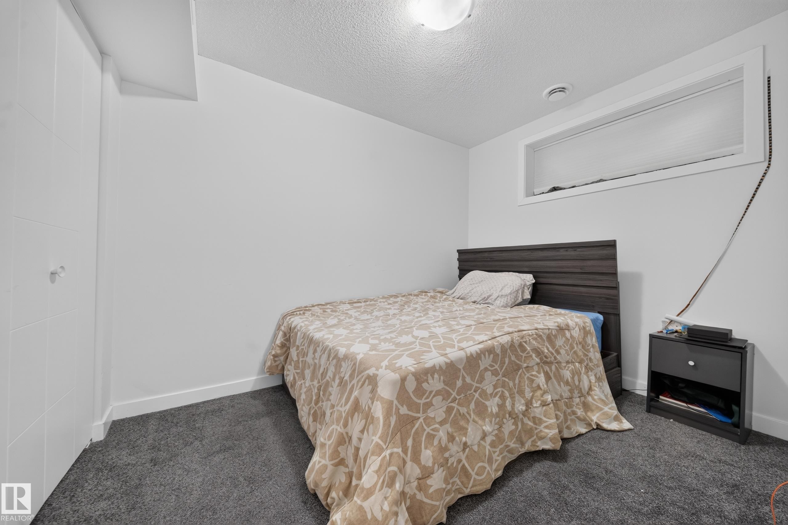 Room featuring textured carpeting and white painted walls - 59 2503 24 Street, Edmonton, AB
