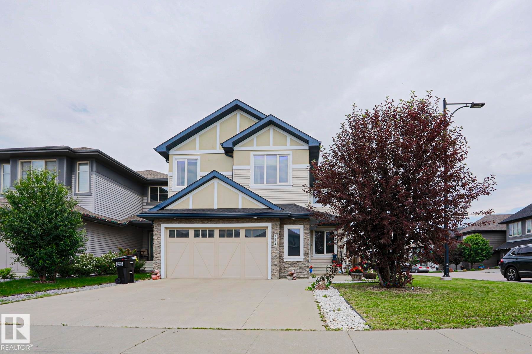 Two-story residence featuring a dual-tone facade with light siding and dark trim accents - 1304 Ainslie Wynd Sw, Edmonton, AB - Outdoor With Facade