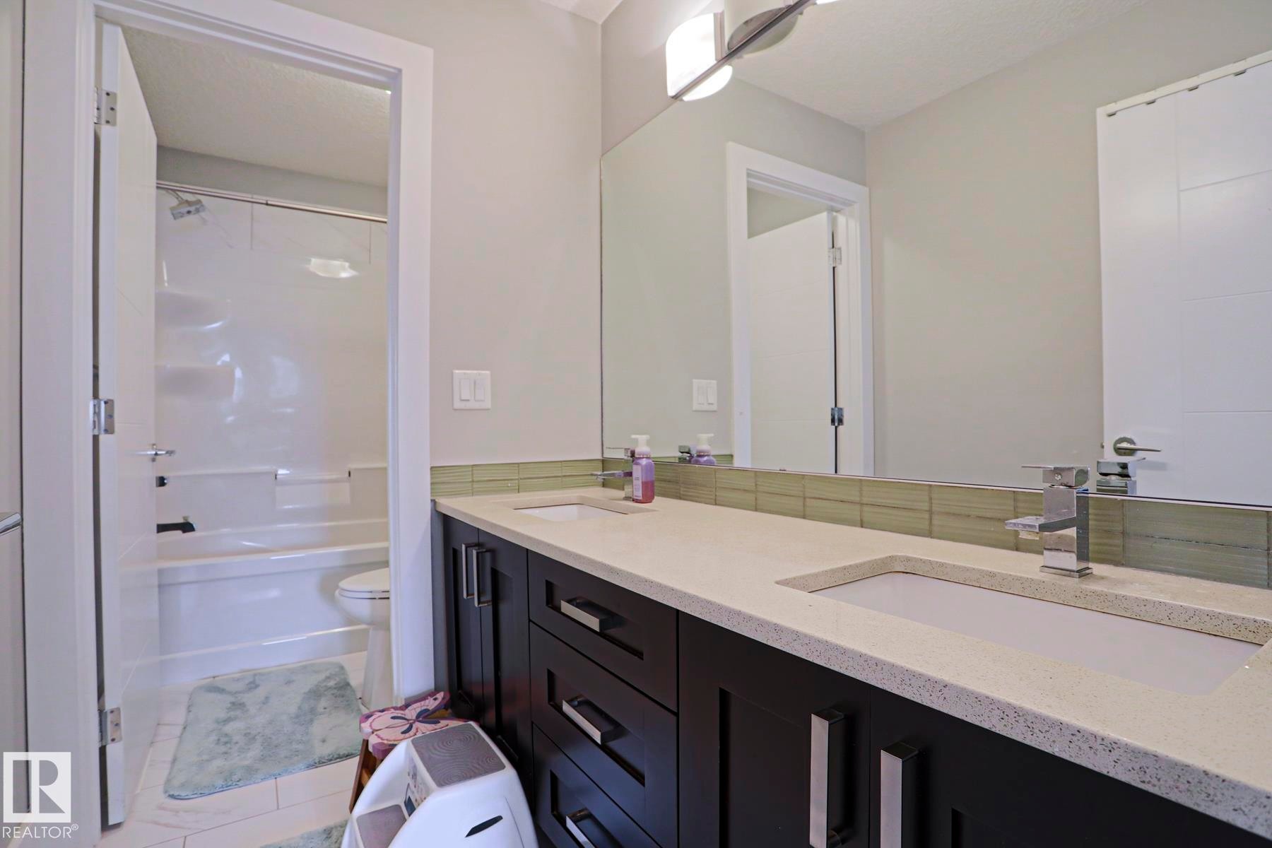 Dual vanity with an integrated countertop and undermount sinks - 1304 Ainslie Wynd Sw, Edmonton, AB - Indoor Photo Showing Bathroom