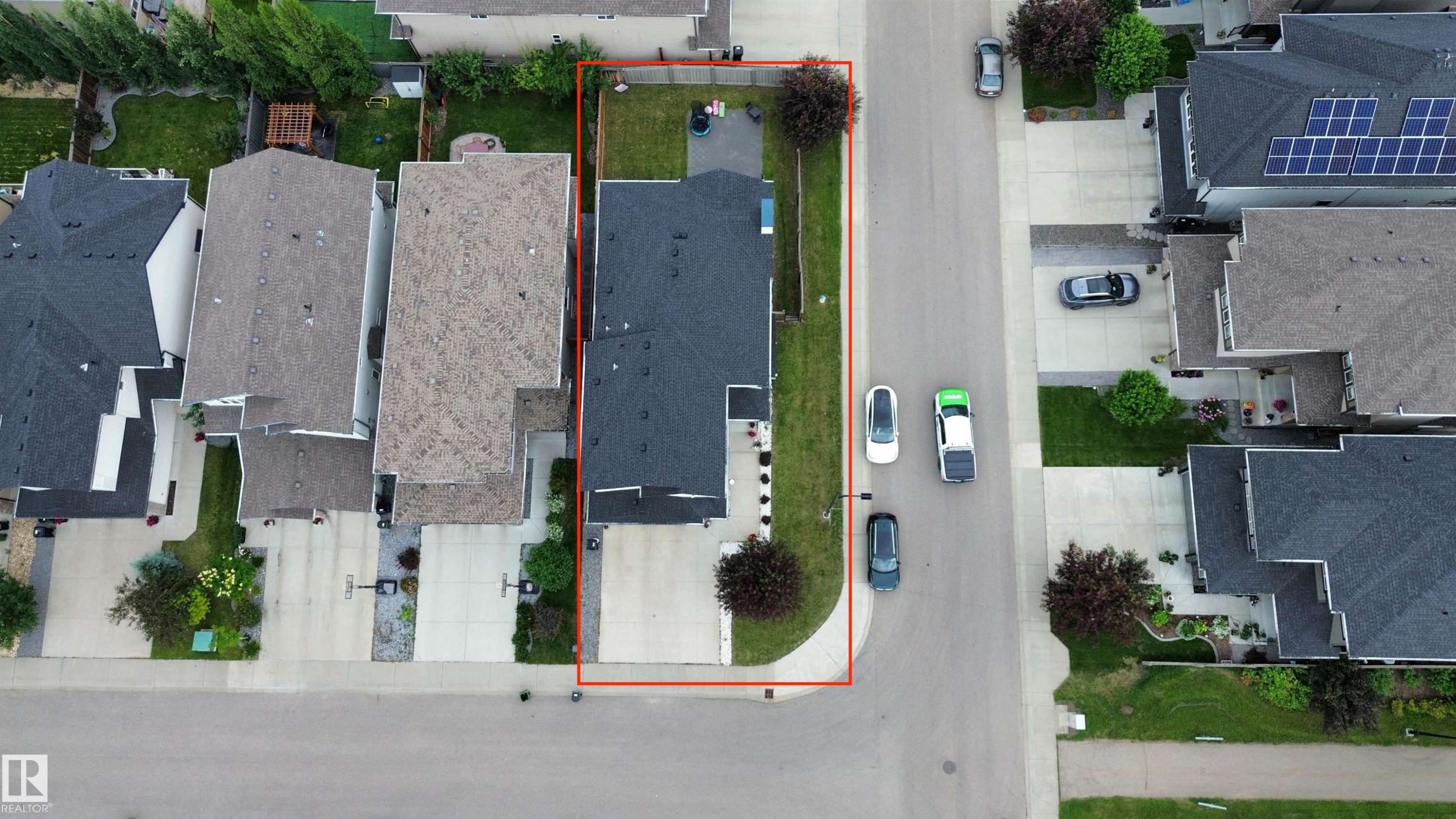 Single-family home featuring a dark shingle roof, concrete driveway, and a fenced backyard with a green lawn - 1304 Ainslie Wynd Sw, Edmonton, AB -