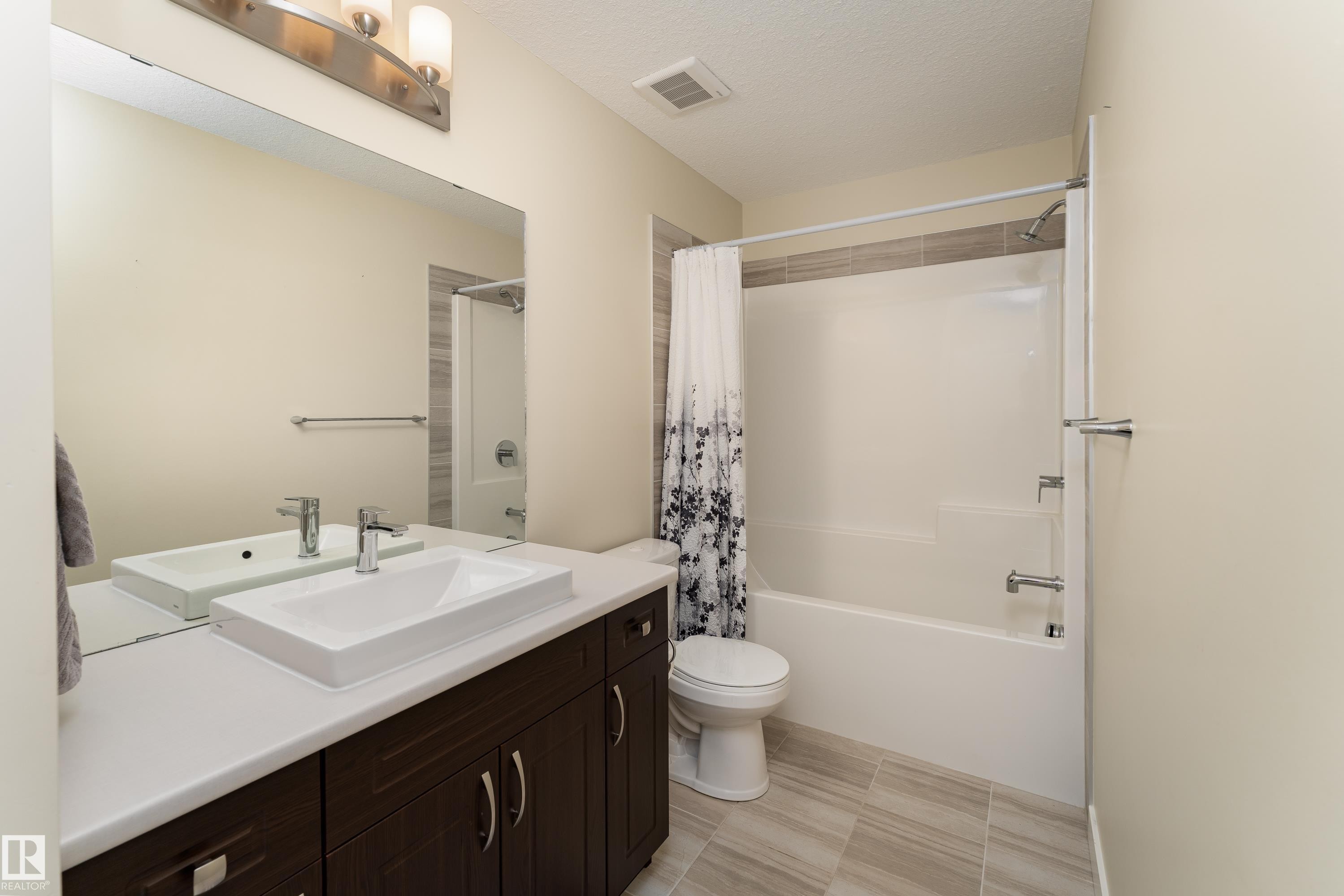 Contemporary bathroom featuring a dark wood-finish vanity with a white countertop and a rectangular vessel sink - 8589 Cushing Place Sw, Edmonton, AB - Indoor Photo Showing Bathroom