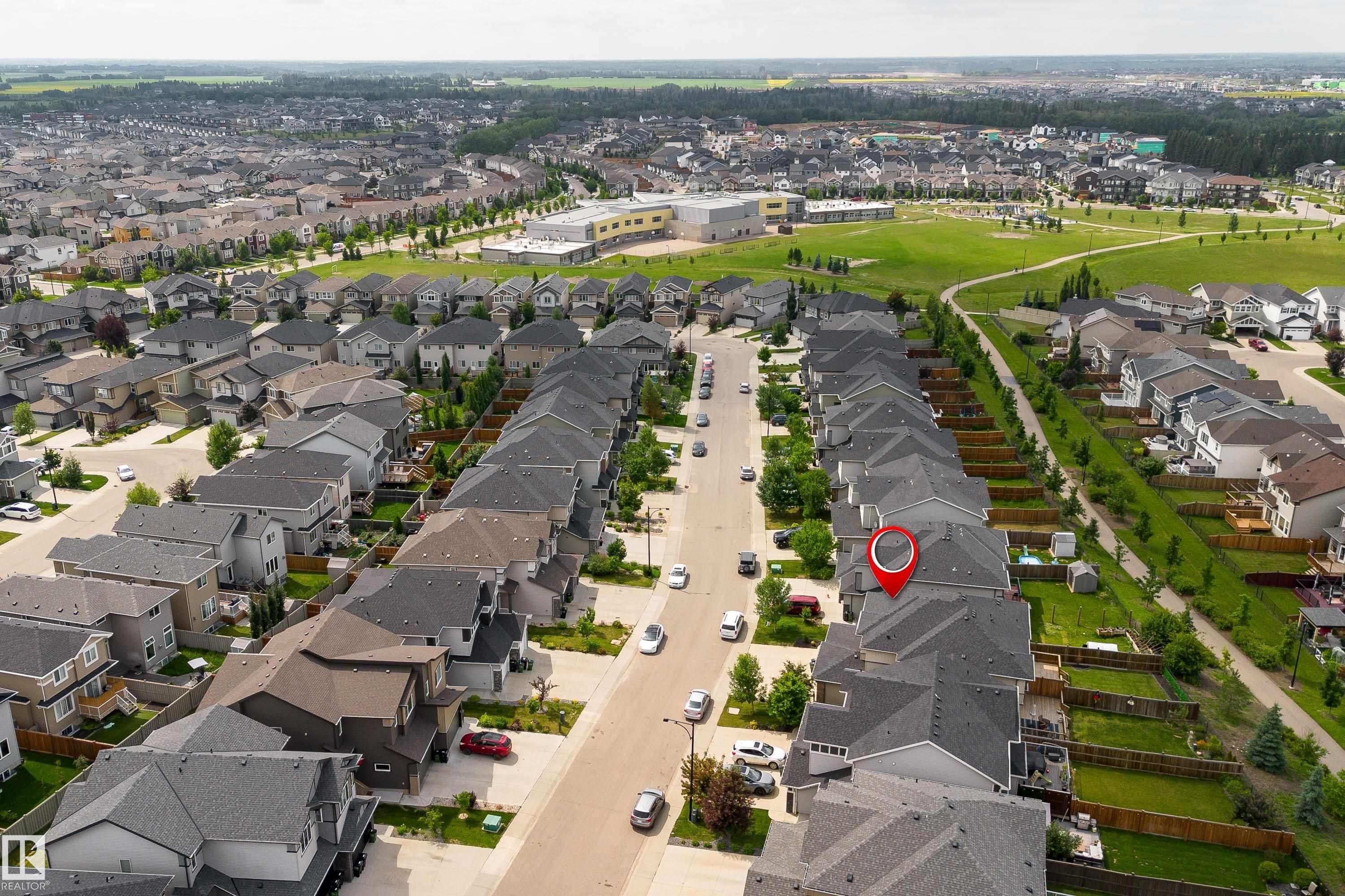 Aerial overview of a residential neighborhood with detached homes, green spaces, and paved streets - 8589 Cushing Place Sw, Edmonton, AB - Outdoor With View