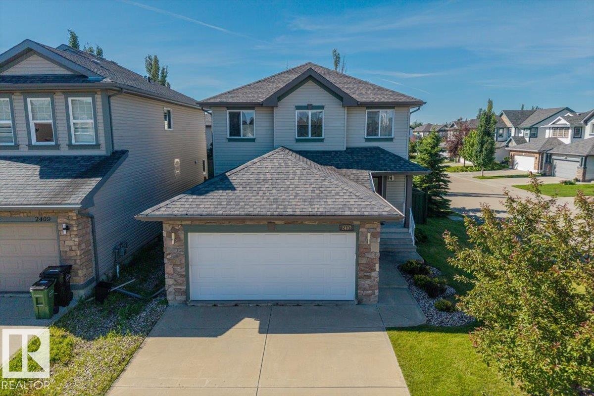 Two-story residential property with light gray siding and dark gray roofing - 2407 Hagen Way, Edmonton, AB