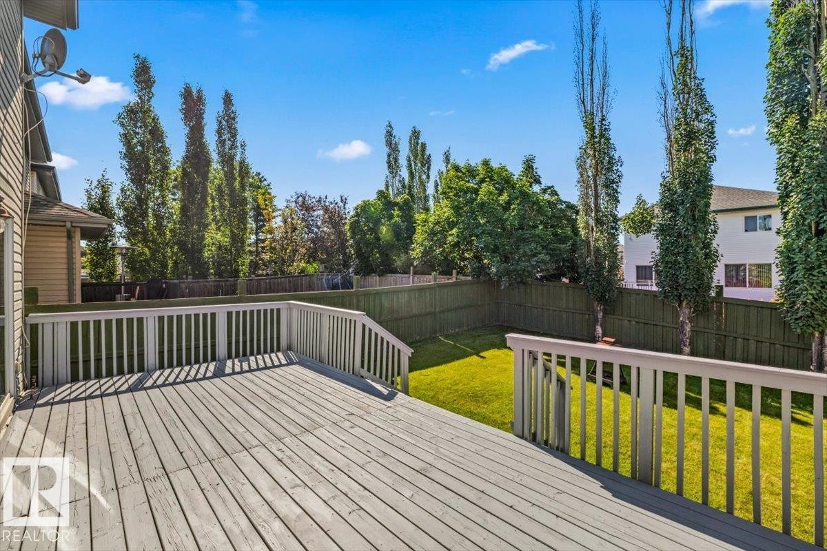 Spacious outdoor deck with railings overlooking a fenced backyard - 2407 Hagen Way, Edmonton, AB