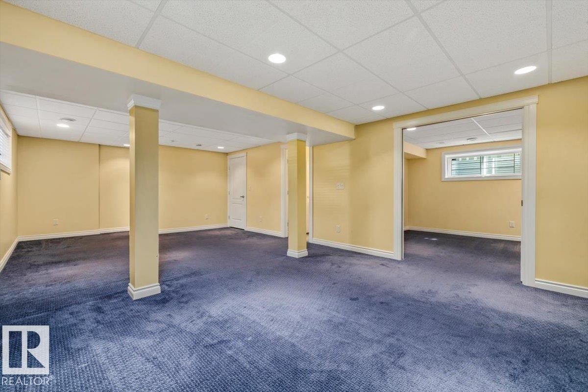 Spacious lower level featuring recessed lighting, a drop ceiling, and a large open entry to an additional room - 2407 Hagen Way, Edmonton, AB