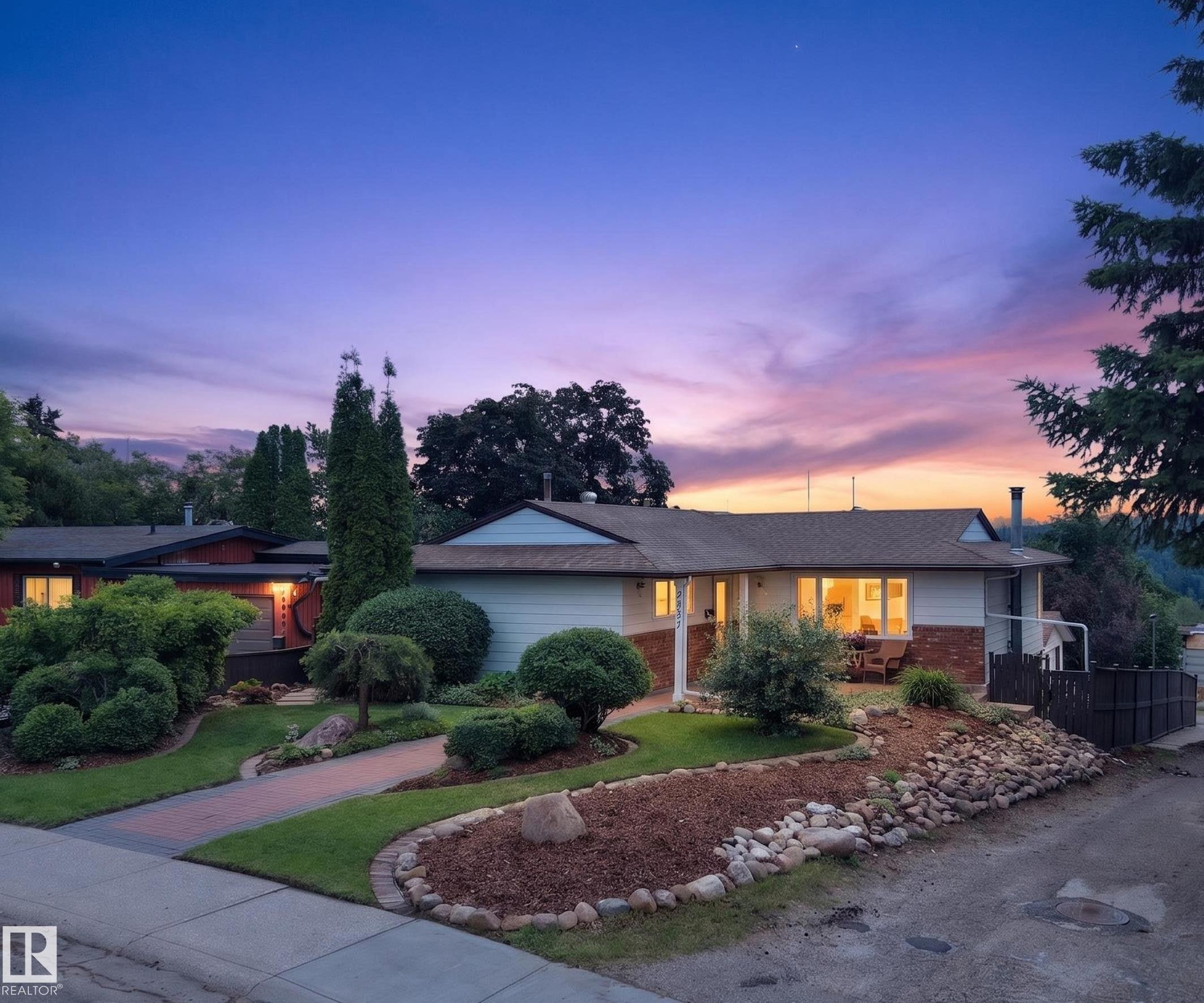 Ranch-style residence featuring a brick facade with light siding, a gabled roofline, and a prominent front porch - 3411 103 Avenue Nw, Edmonton, AB