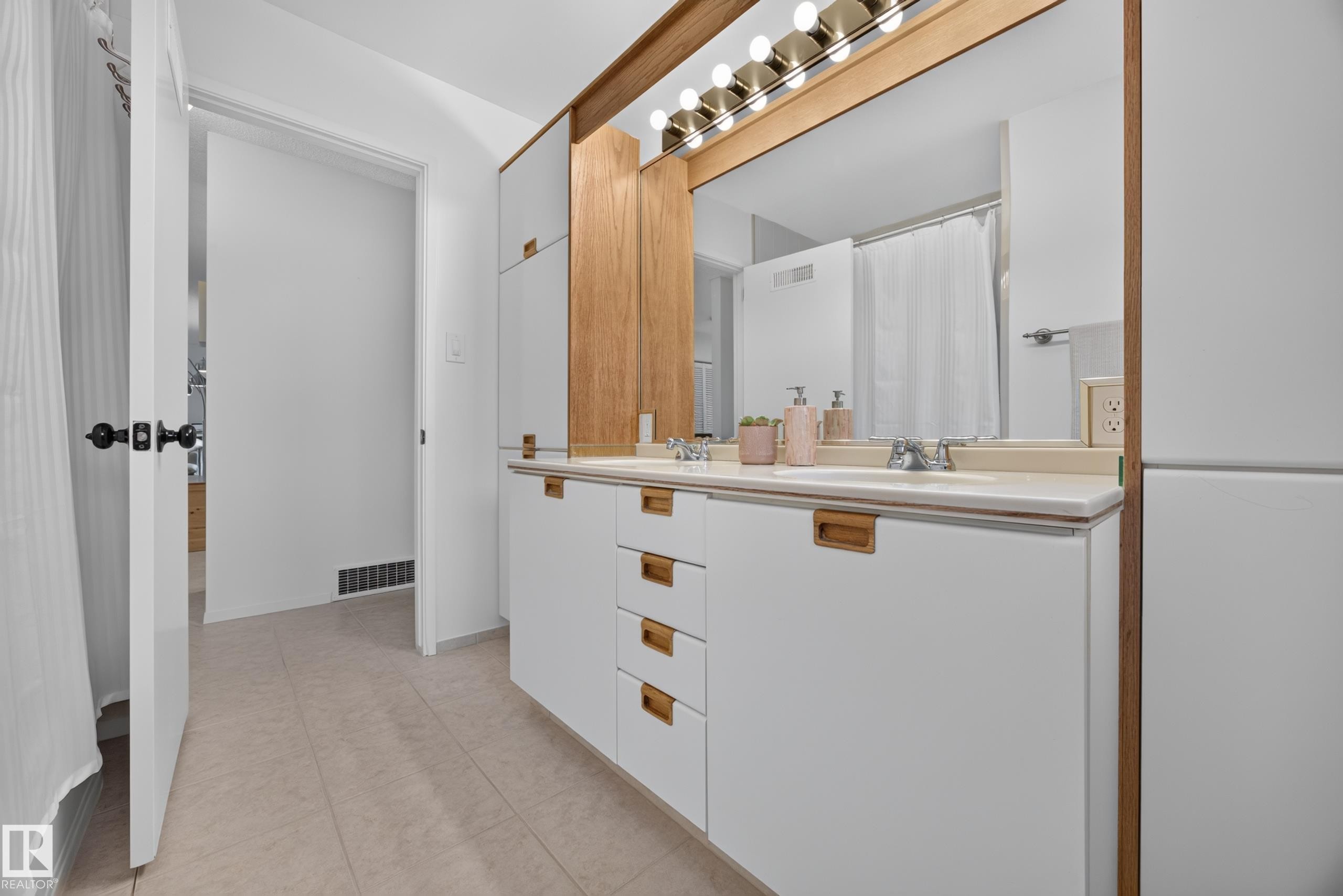 Dual vanity featuring white cabinetry with wood-finish hardware and a light-toned countertop - 3411 103 Avenue Nw, Edmonton, AB