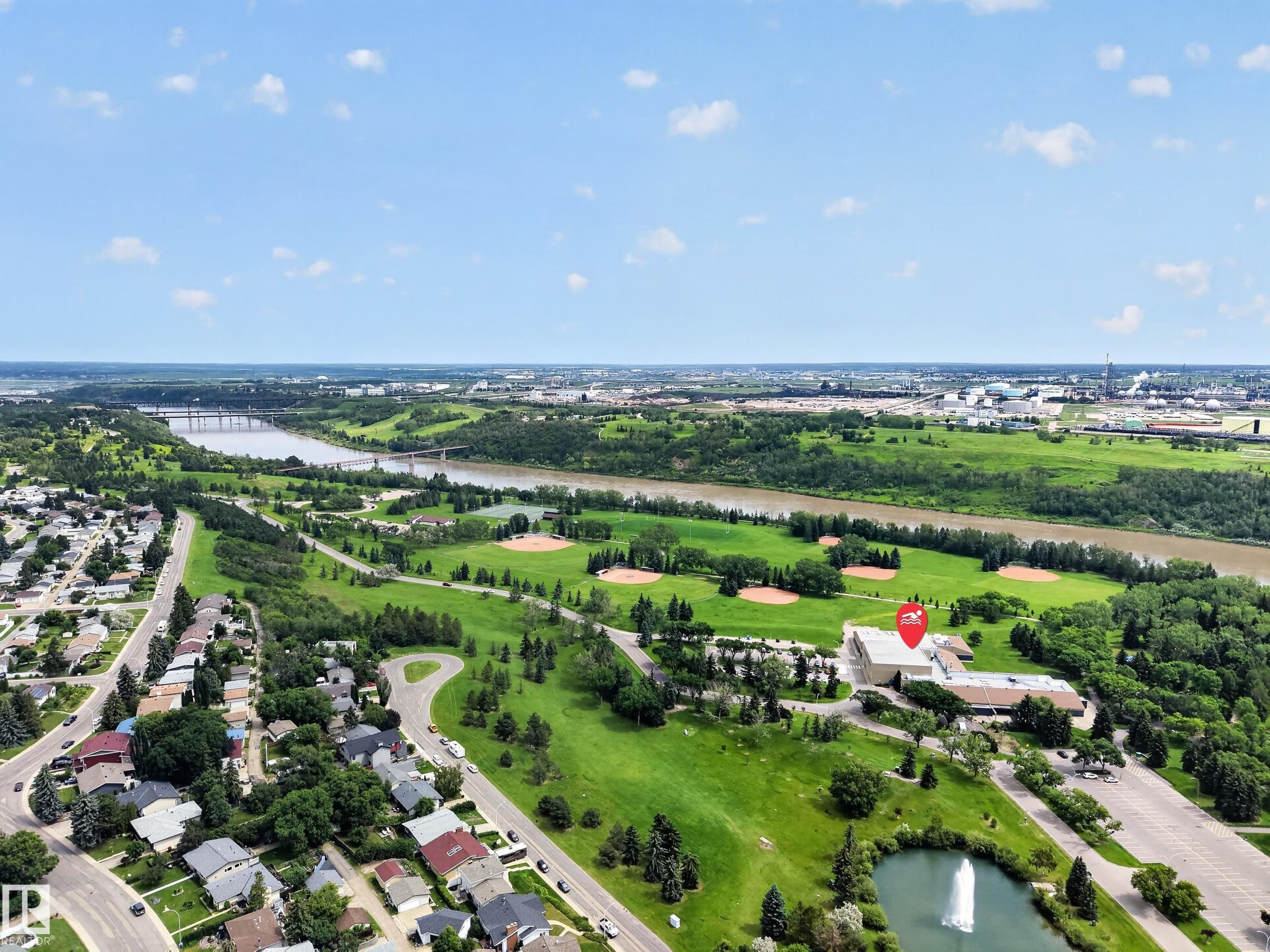 Aerial perspective featuring a river, surrounding green spaces, residential areas, and a prominent commercial building - 3411 103 Avenue Nw, Edmonton, AB