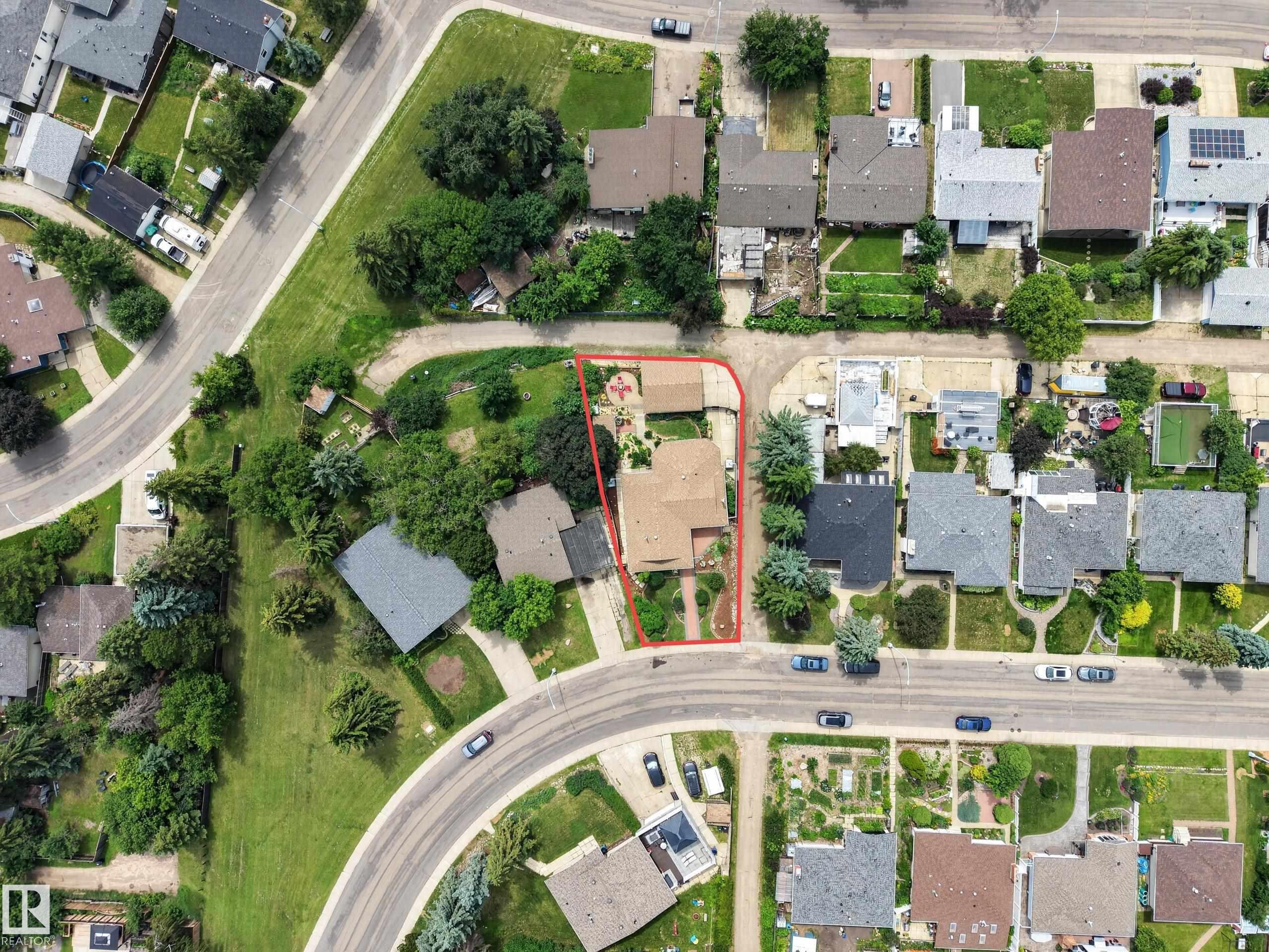 Aerial perspective showcasing a residential property with a detached garage, established landscaping, and a curvilinear street frontage - 3411 103 Avenue Nw, Edmonton, AB