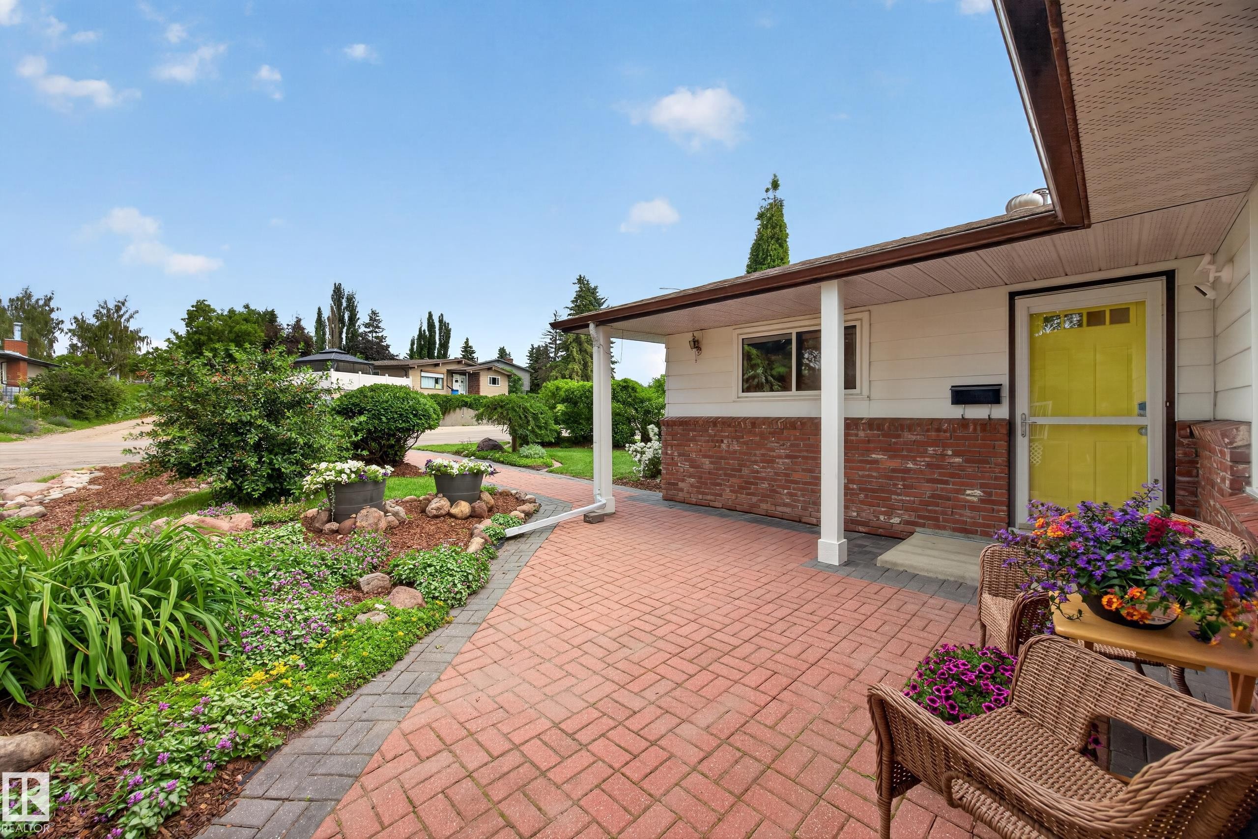 Brick paver walkway leading to a covered entry with a vibrant yellow door - 3411 103 Avenue Nw, Edmonton, AB