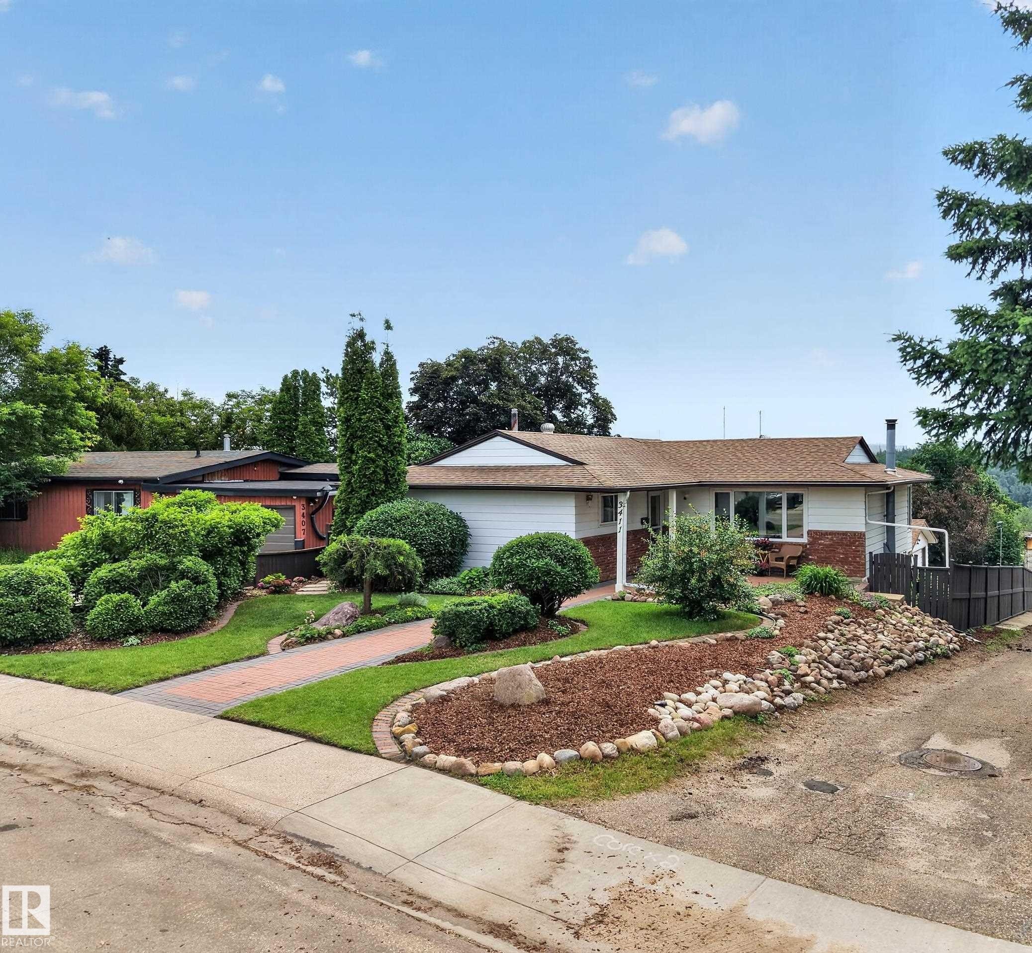 Single-story residence featuring a white siding exterior with brick accents and a brown shingle roof - 3411 103 Avenue Nw, Edmonton, AB