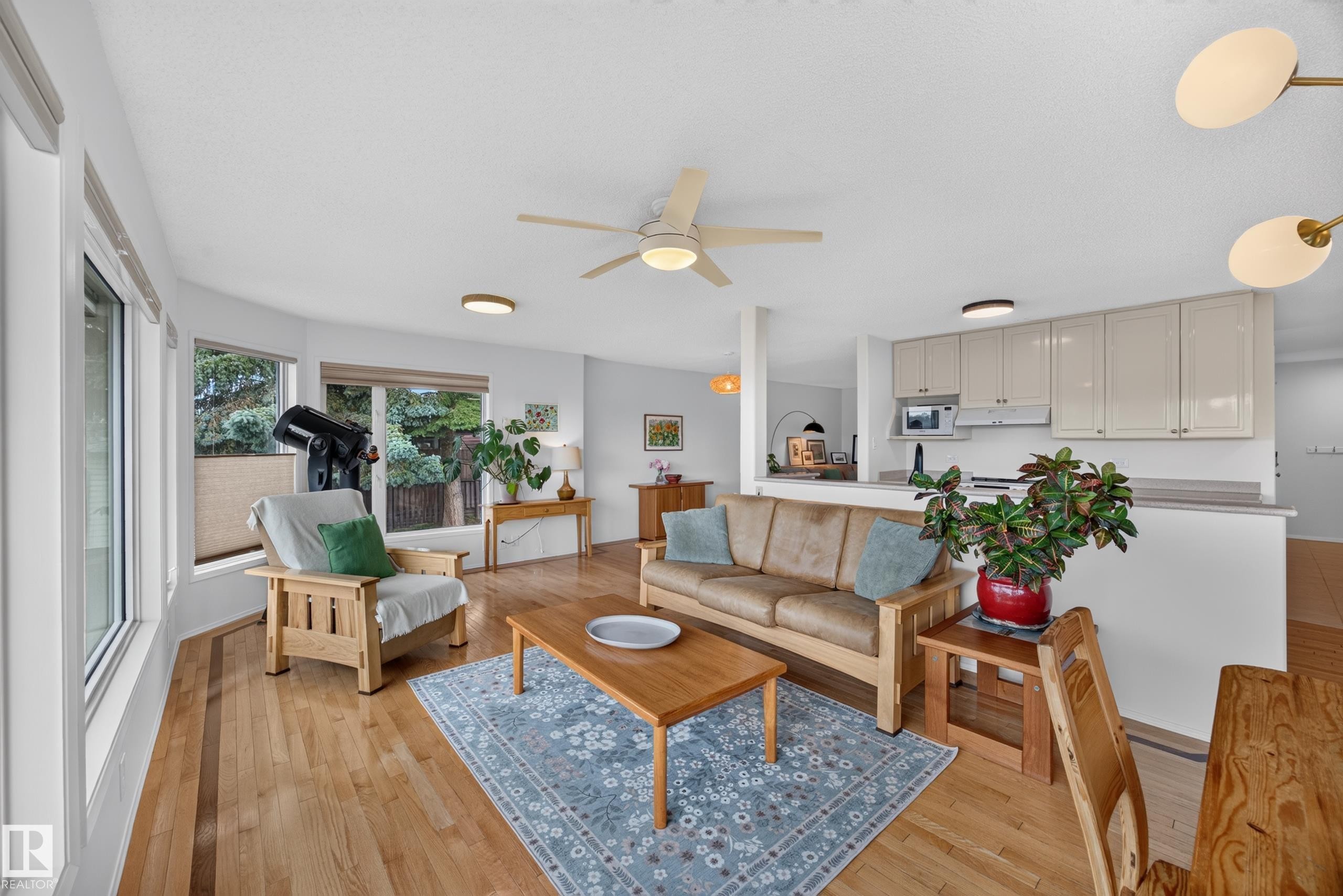 Open-concept living area with wood-finish flooring, a ceiling fan, and recessed lighting - 3411 103 Avenue Nw, Edmonton, AB