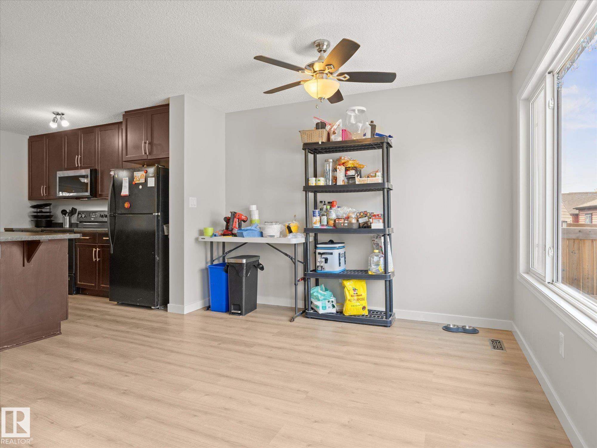 Open-concept living space with light wood-finish flooring - 473 Orchards Boulevard Sw, Edmonton, AB - Indoor Photo Showing Kitchen