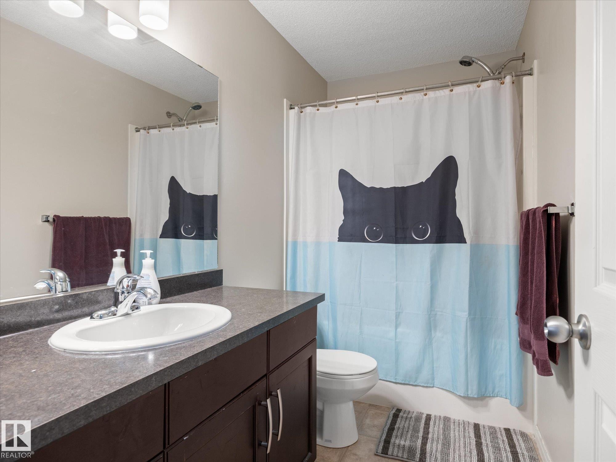 Bathroom vanity with a dark wood-finish cabinet and integrated oval sink - 473 Orchards Boulevard Sw, Edmonton, AB - Indoor Photo Showing Bathroom